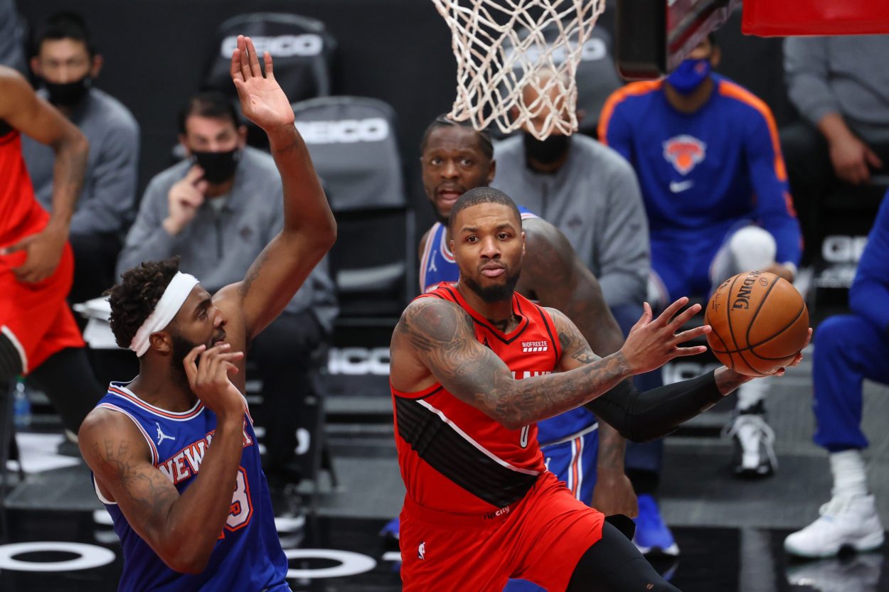 Portland Trail Blazers guard Damian Lillard passes around New York Knicks center Mitchell Robinson during an NBA game in January 2021