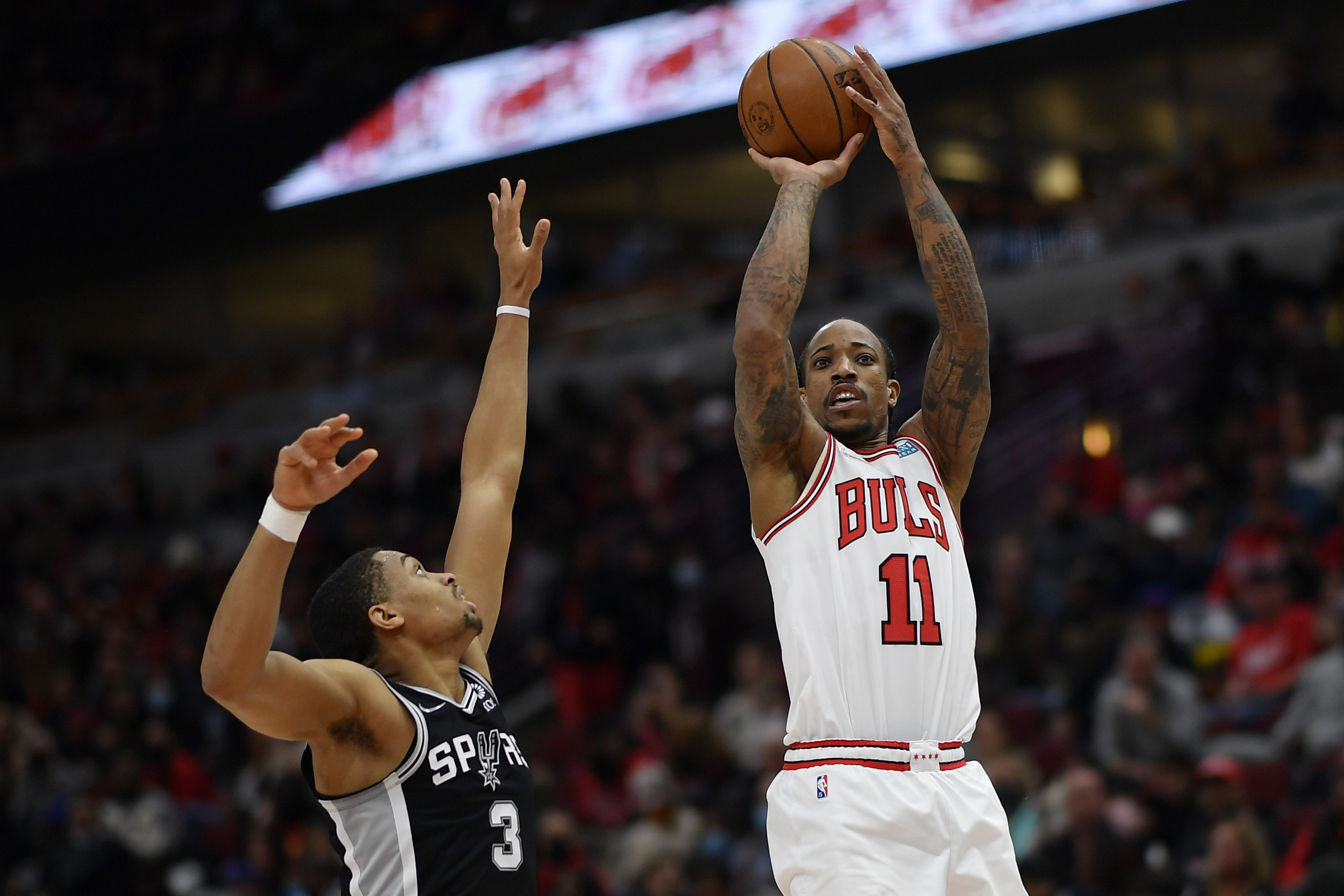 Chicago Bulls star DeMar DeRozan shoots over San Antonio Spurs wing Keldon Johnson during an NBA game in February 2022