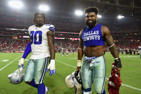 Running back Ezekiel Elliott of the Dallas Cowboys and defensive end Demarcus Lawrence walk off the field after the NFL game against the Arizona Cardinals at the University of Phoenix Stadium on September 25, 2017 in Glendale, Arizona. Dallas won 28-17. The pair is among the worst Dallas Cowboys contracts of 2022.