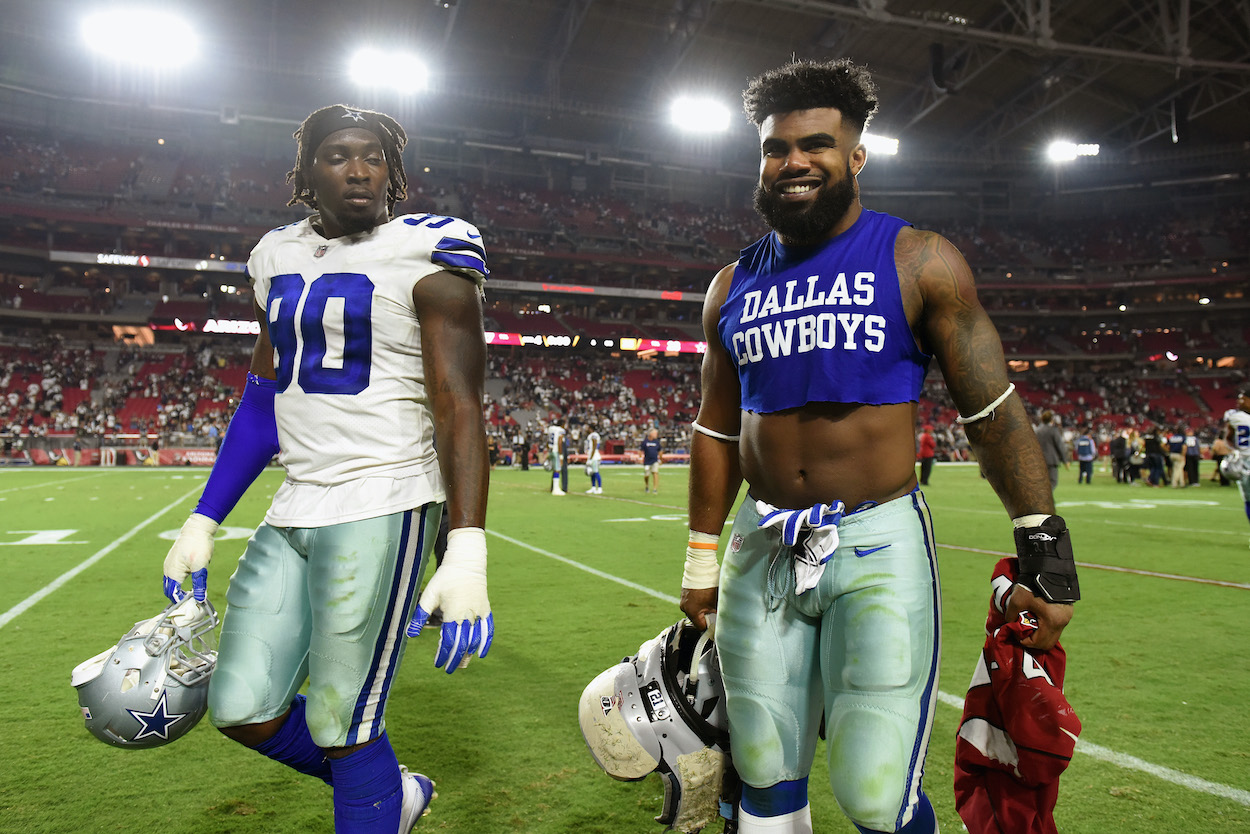 Running back Ezekiel Elliott of the Dallas Cowboys and defensive end Demarcus Lawrence walk off the field after the NFL game against the Arizona Cardinals at the University of Phoenix Stadium on September 25, 2017 in Glendale, Arizona. Dallas won 28-17. The pair is among the worst Dallas Cowboys contracts of 2022.