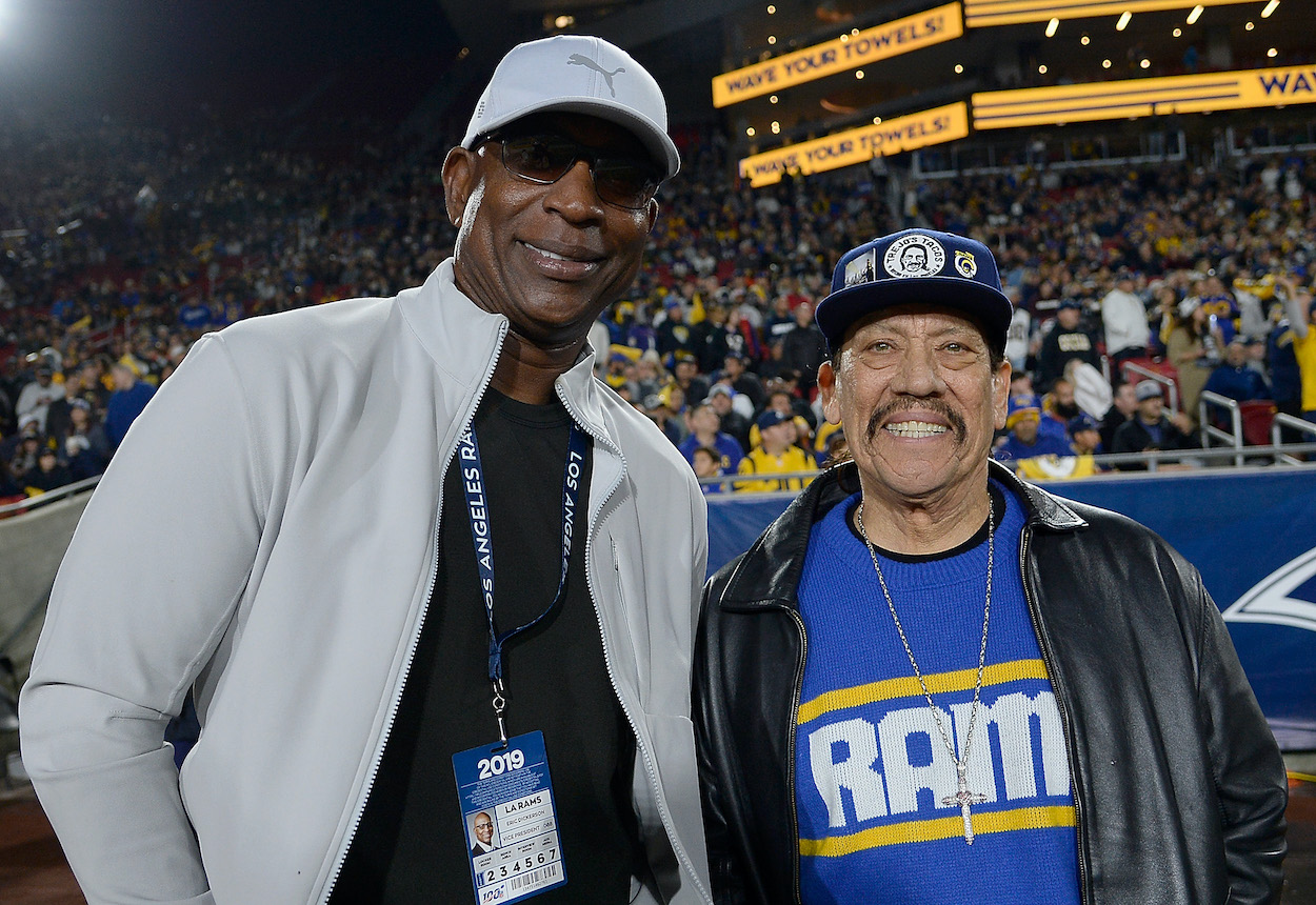 Eric Dickerson, former LA Rams player and NFL Hall of Famer (L) and actor, Danny Trejo pose for photos on the sidelines of the game between the Los Angeles Rams and the Baltimore Ravens at Los Angeles Memorial Coliseum on November 25, 2019.