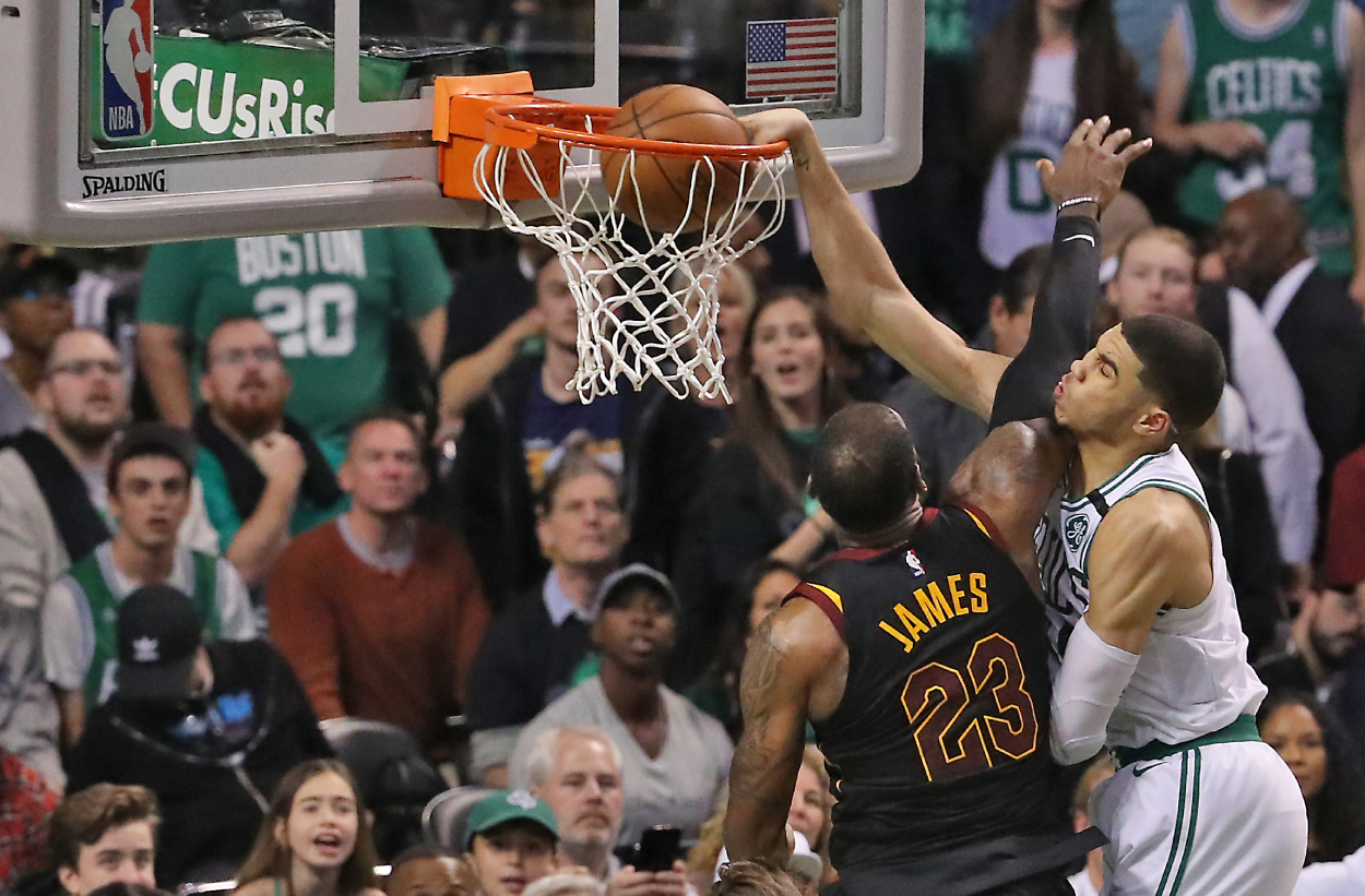 Boston Celtics Jayson Tatum scores on a slam dunk on Cleveland Cavaliers LeBron James.