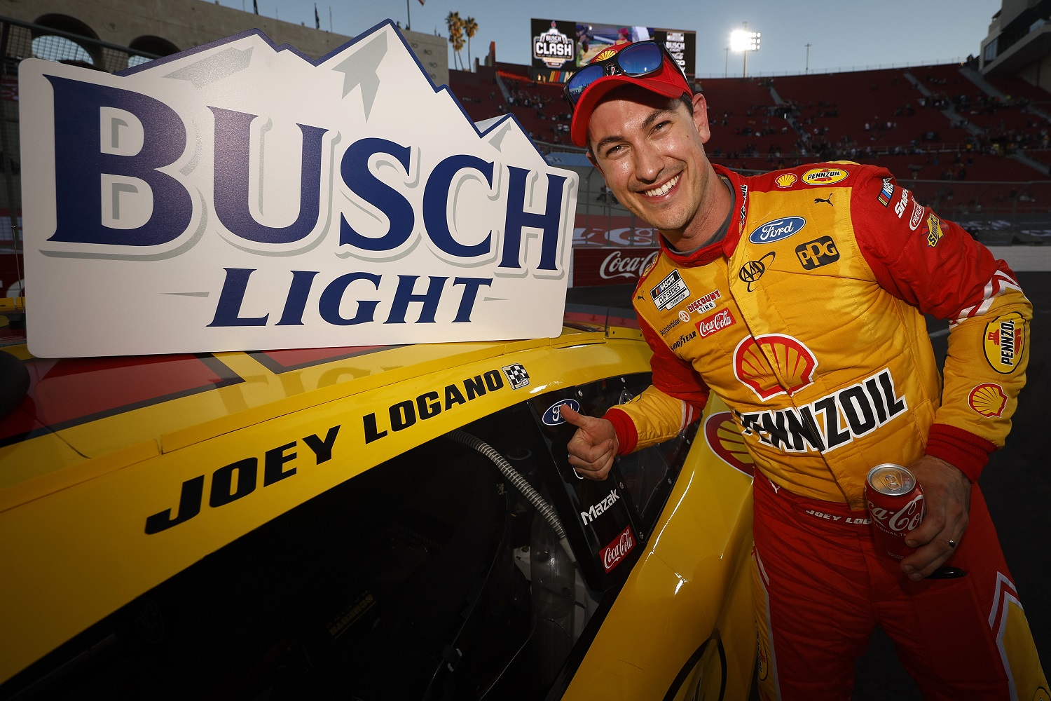 Joey Logano poses after placing the winner's sticker in Victory Lane after winning the NASCAR Cup Series Busch Light Clash at the Los Angeles Memorial Coliseum.