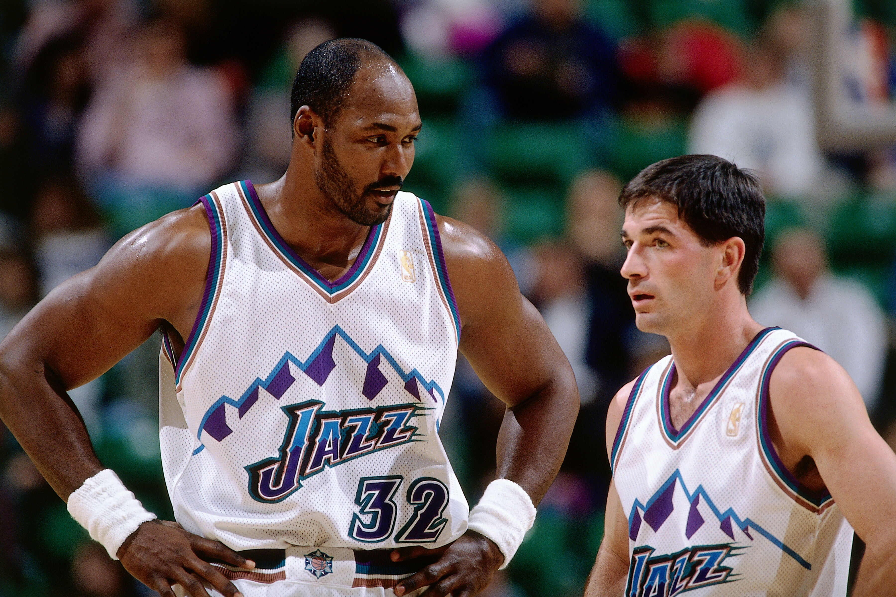 Utah Jazz greats Karl Malone and John Stockton talk during an NBA game in 1997