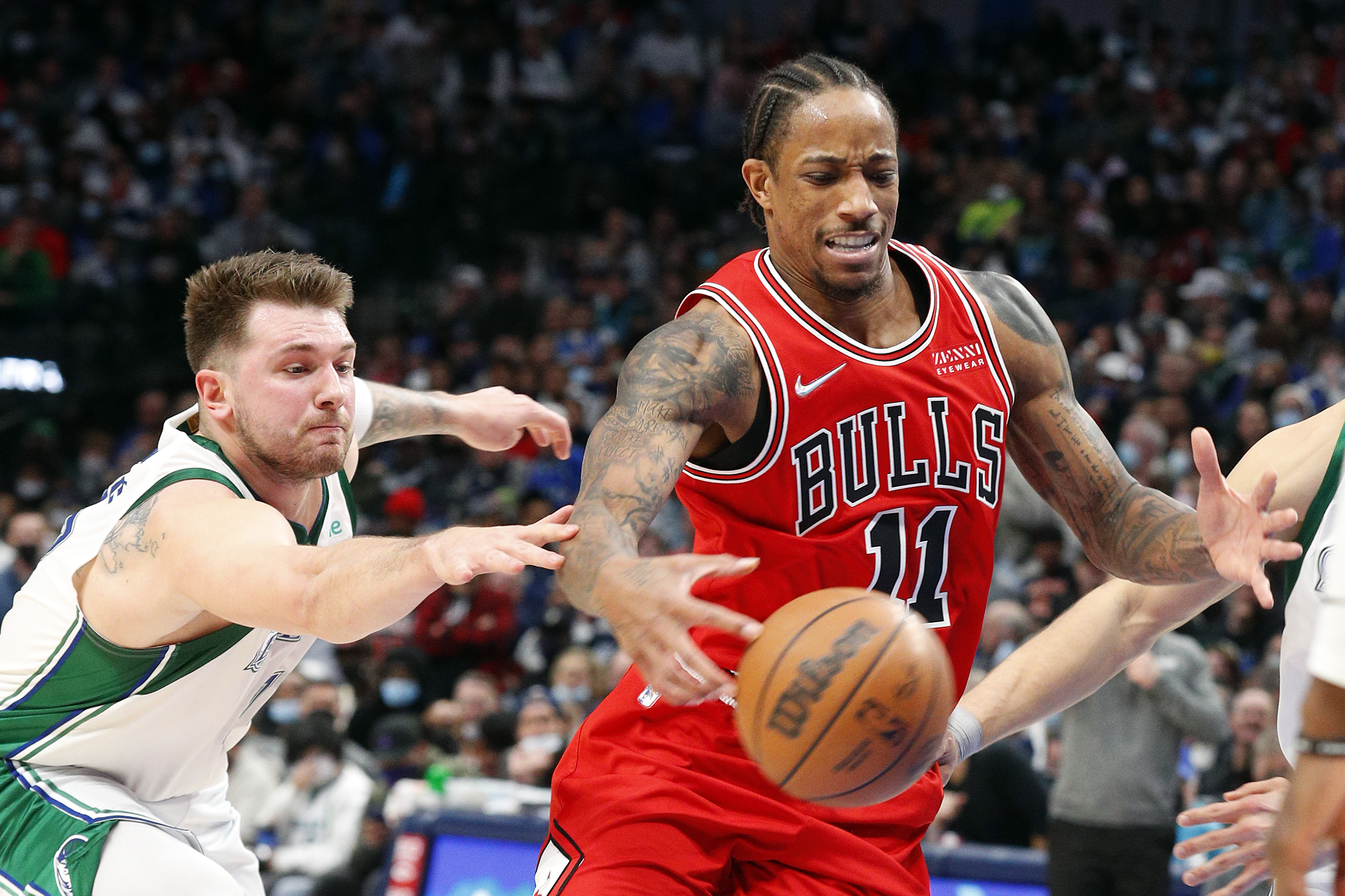Dallas Mavericks guard Luka Doncic tries to steal the ball from Chicago Bulls star DeMar DeRozan during an NBA game in January 2022