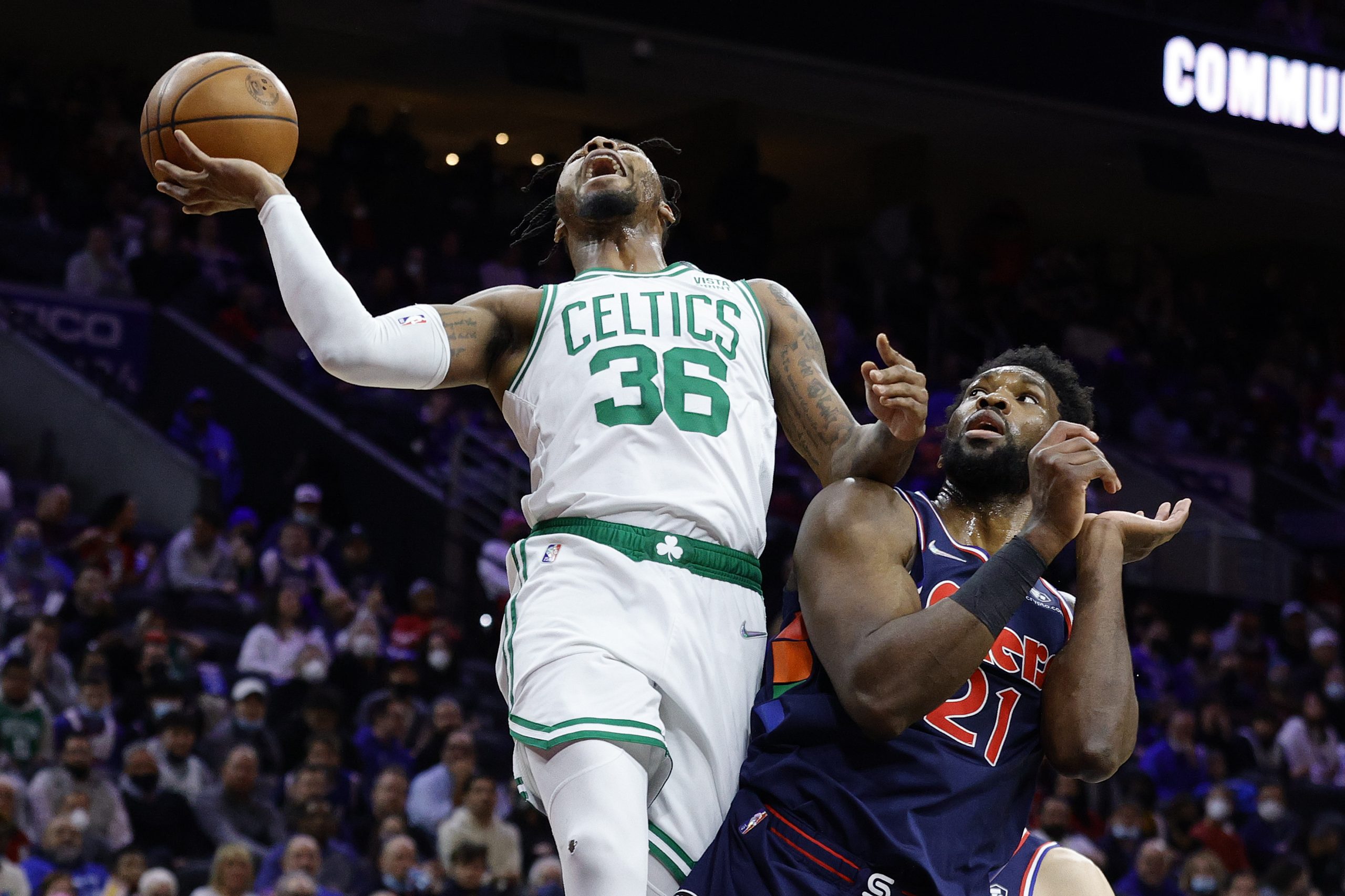 Marcus Smart of the Boston Celtics is fouled by Joel Embiid of the Philadelphia 76ers.