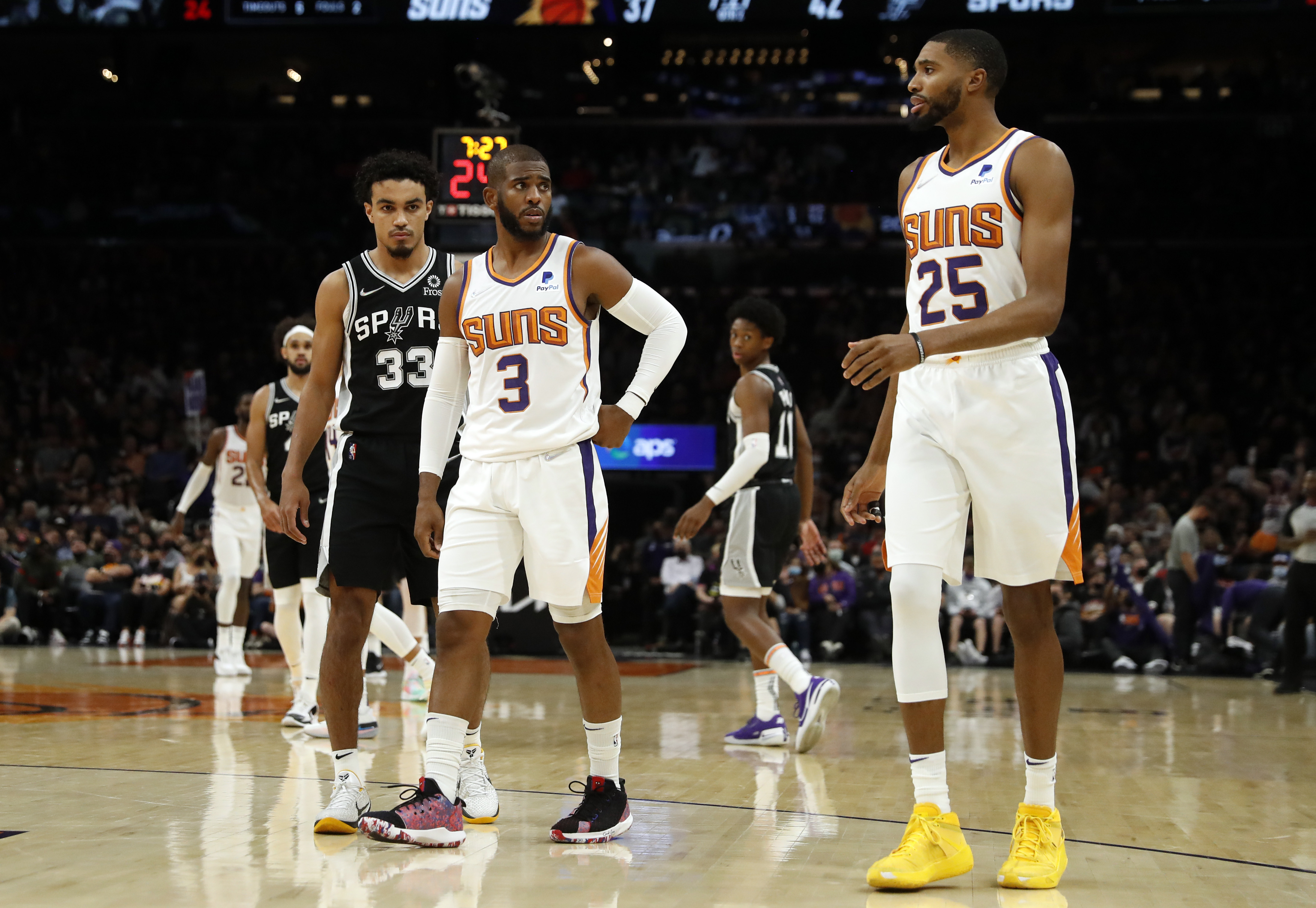 Phoenix Suns point guard Chris Paul talks with Mikal Bridges during an NBA game against the San Antonio Spurs in December 2021
