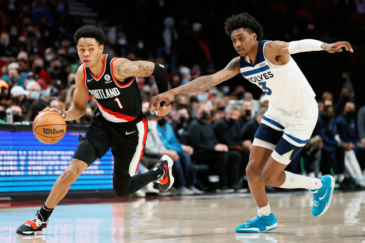 Rising Portland Trail Blazers star Anfernee Simons dribbles around Minnesota Timberwolves guard Jaden McDaniels during the first half at Moda Center on January 25, 2022 in Portland, Oregon.