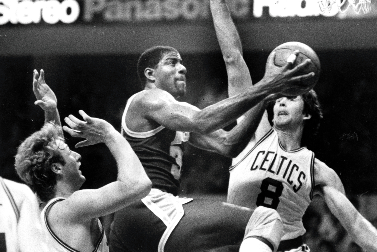 Los Angeles Lakers' Magic Johnson splits the defense of Celtics' Larry Bird, left, and Scott Wedman.