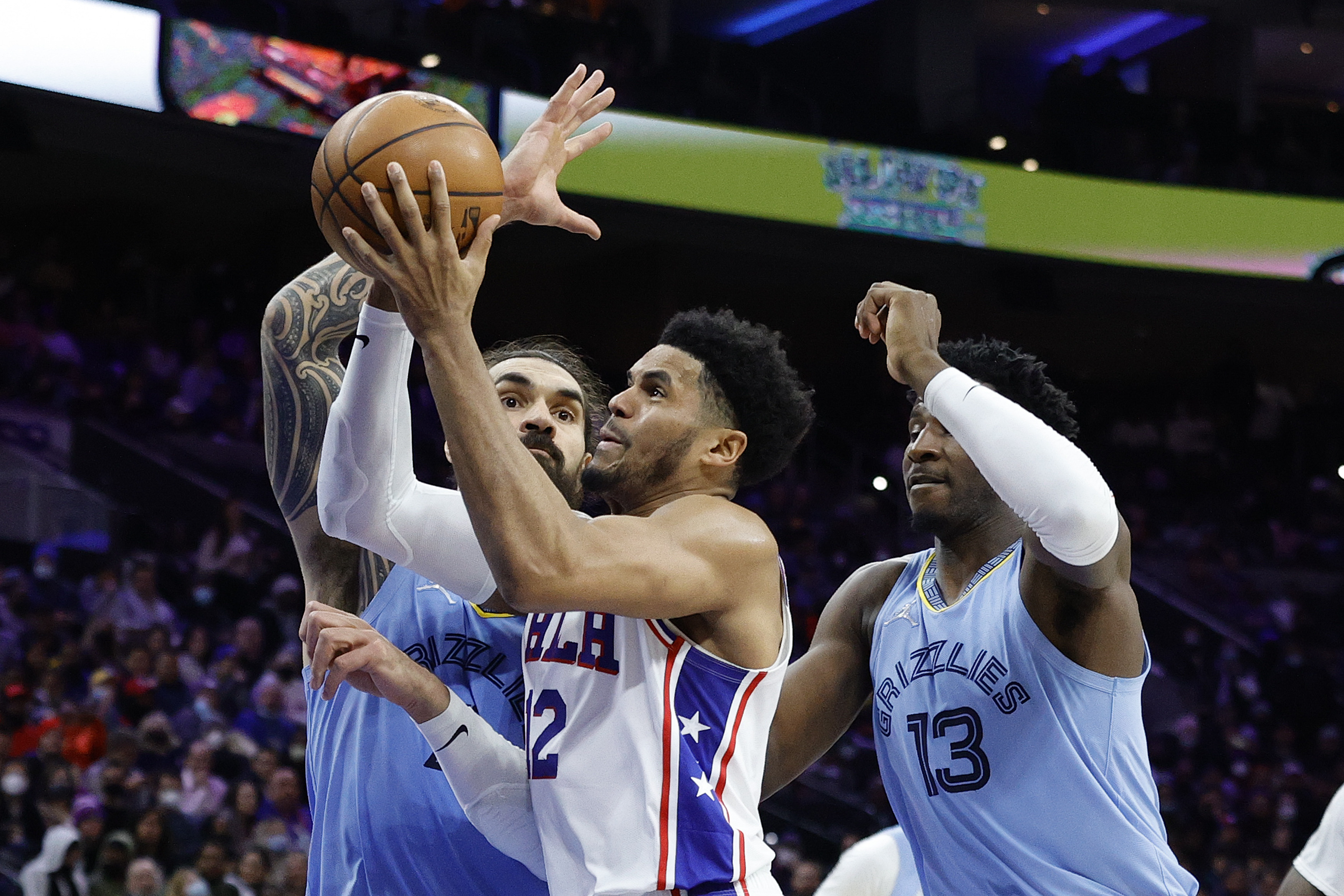 Philadelphia 76ers forward Tobias Harris drives past Memphis Grizzlies big men Steven Adams (L) and Jaren Jackson Jr. (R) during an NBA game in January 2022