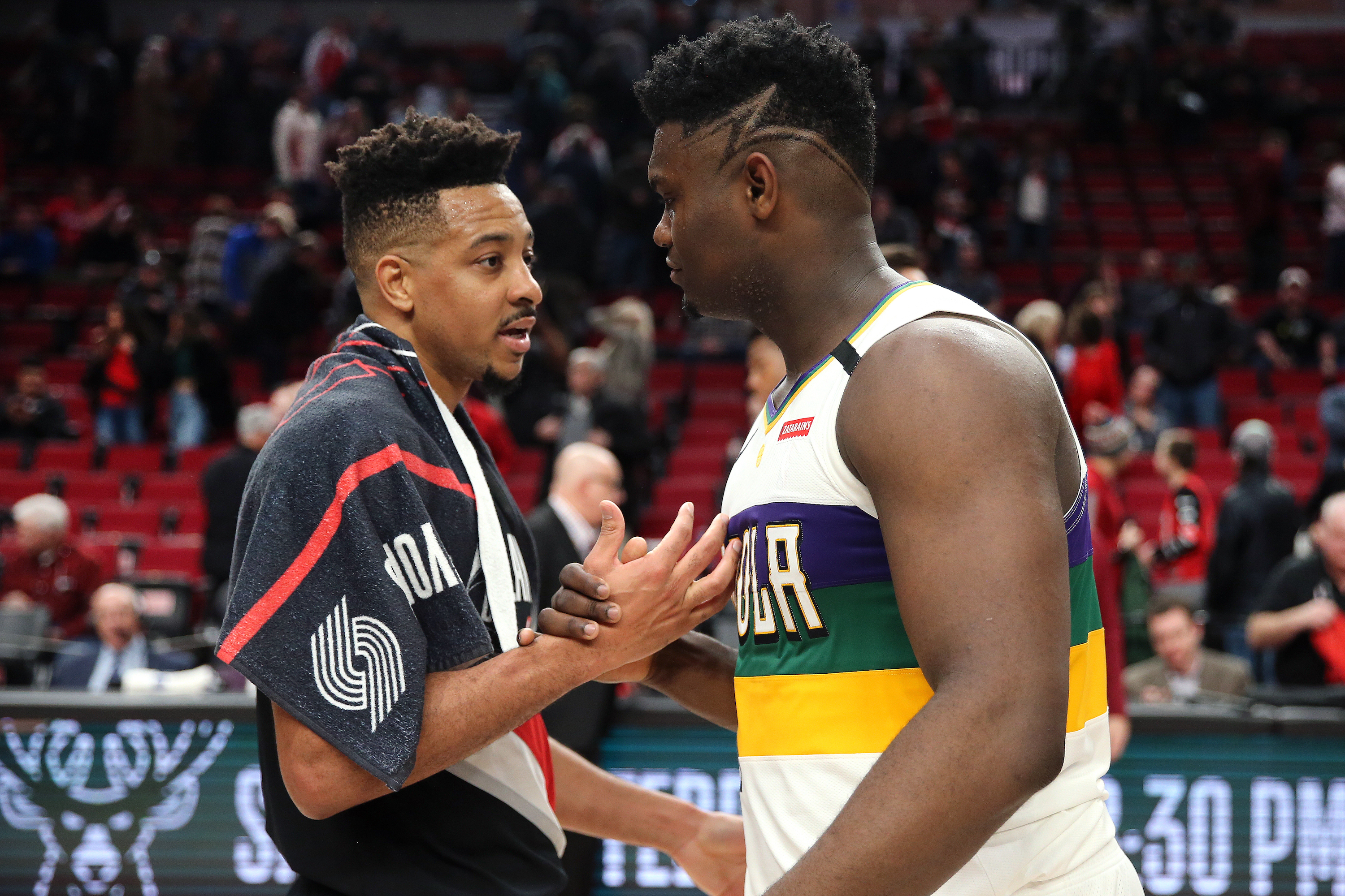 New Orleans Pelicans star Zion Williamson shakes hands with CJ McCollum during an NBA game in February 2020