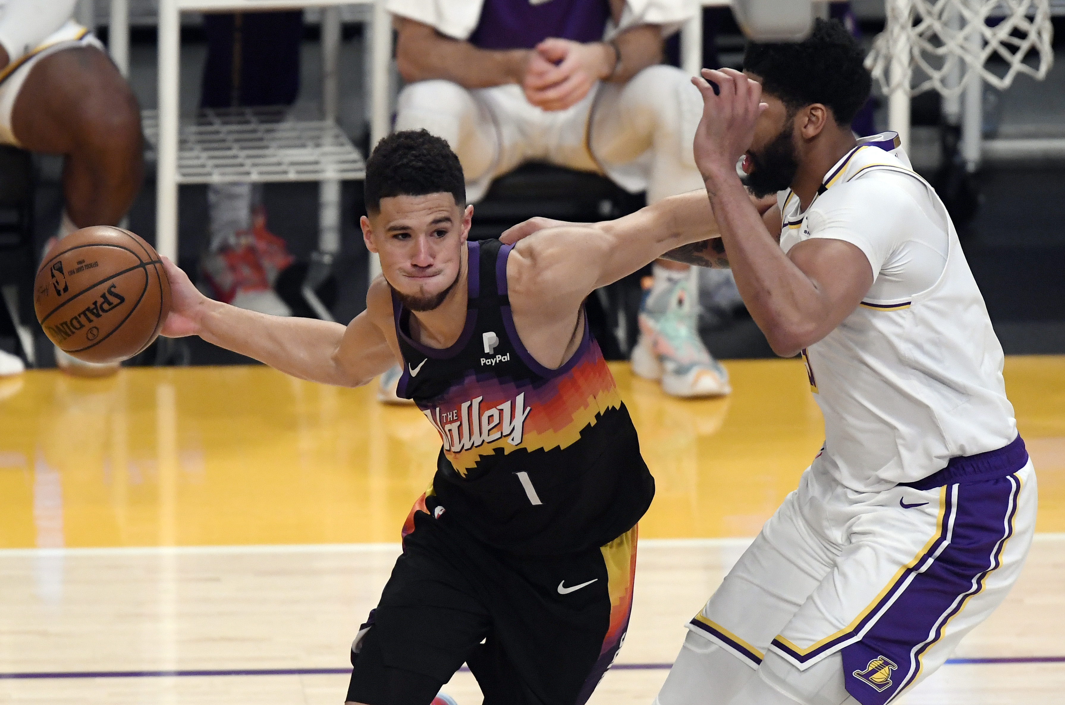 Phoenix Suns guard Devin Booker drives on Los Angeles Lakers forward Anthony Davis during an NBA game in May 2021