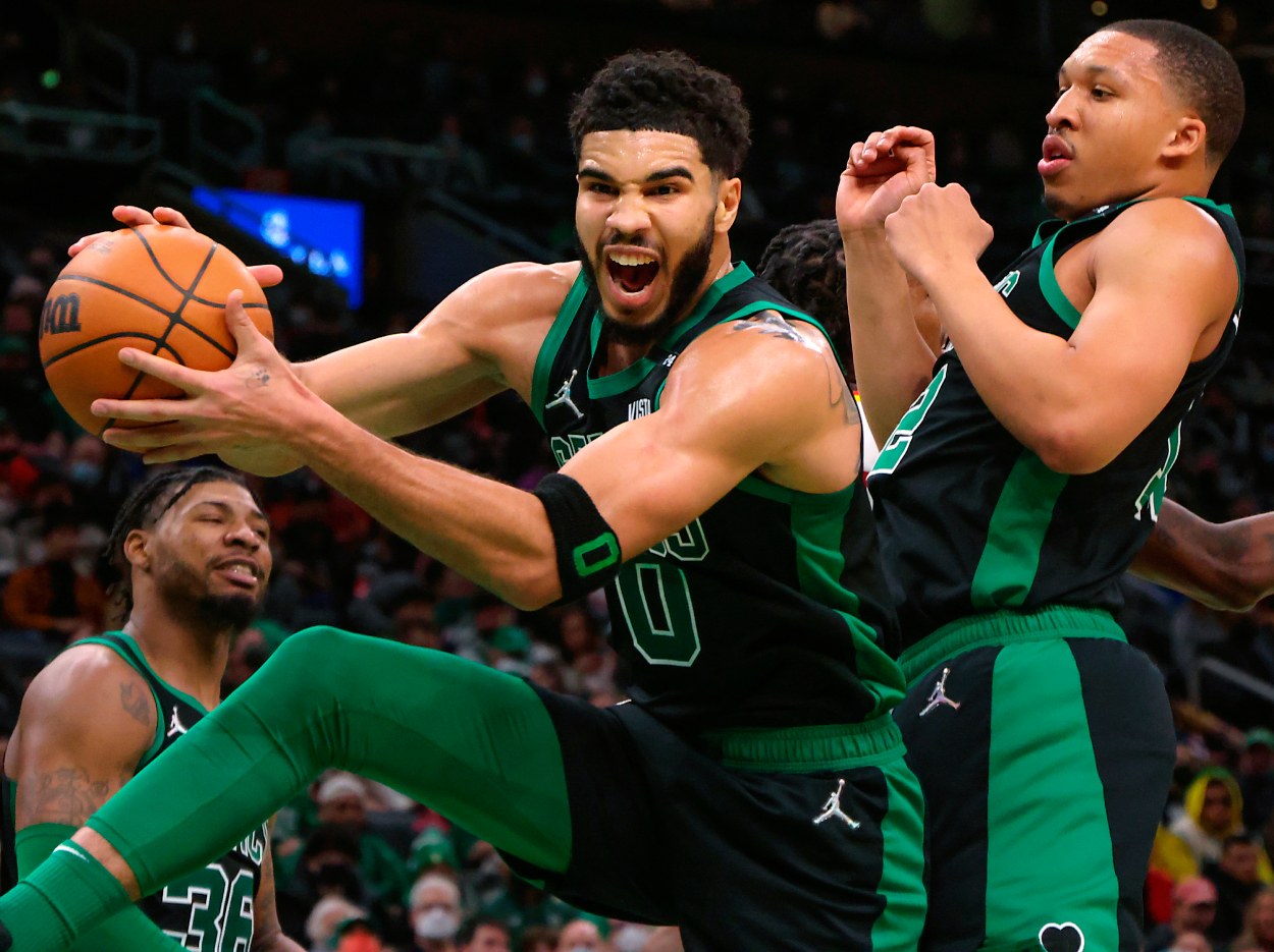 Boston Celtics forward Jayson Tatum pulls down a defensive rebound in front of teammate forward Grant Williams.