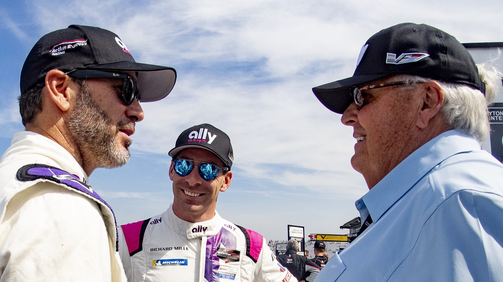 Jimmie Johnson, left, talks with Rick Hendrick, right, and Simon Pagenaud in the pits before the Sahlens Six Hours at the Glen IMSA race on June 27, 2021.