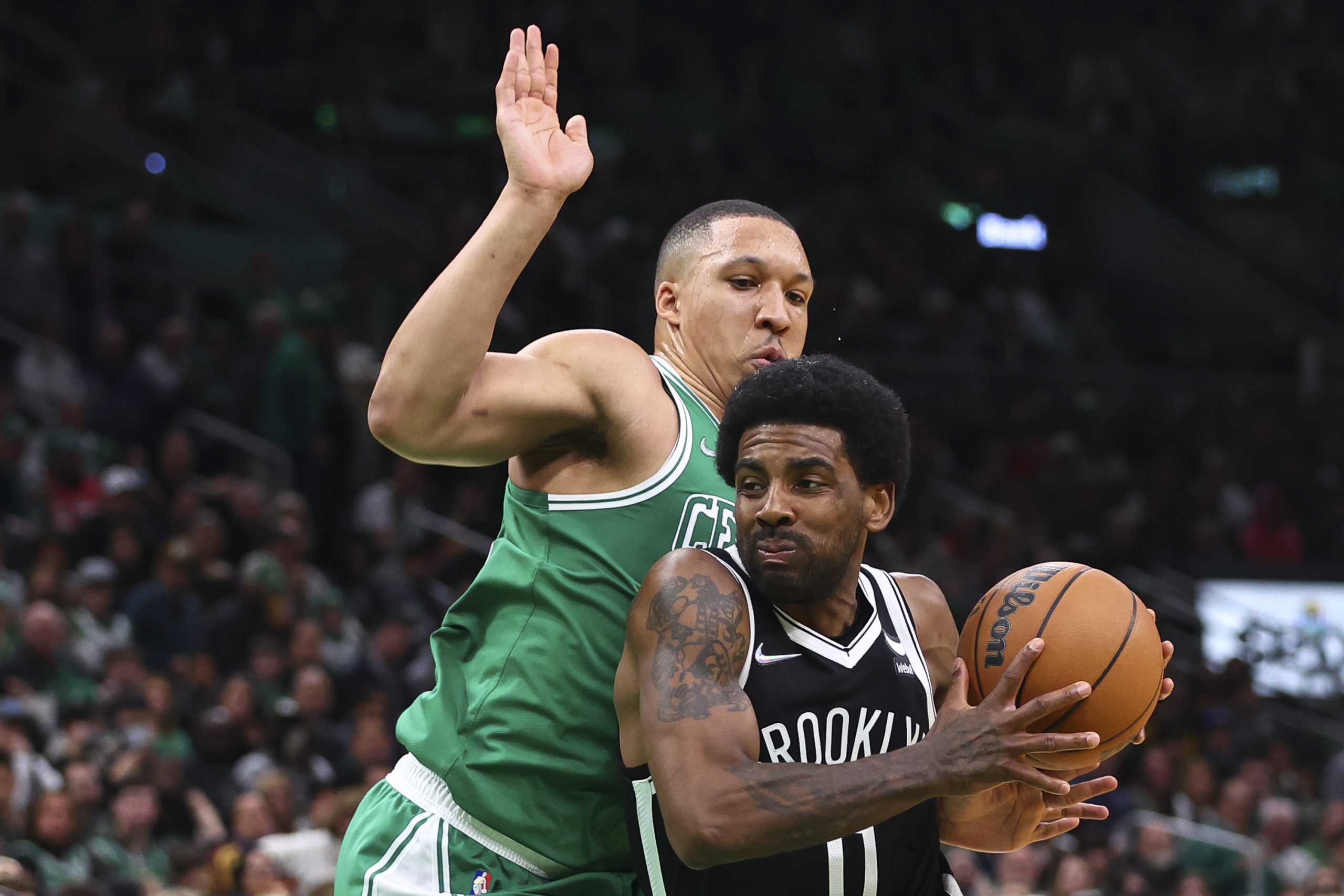 Grant Williams of the Boston Celtics guards Kyrie Irving of the Brooklyn Nets.