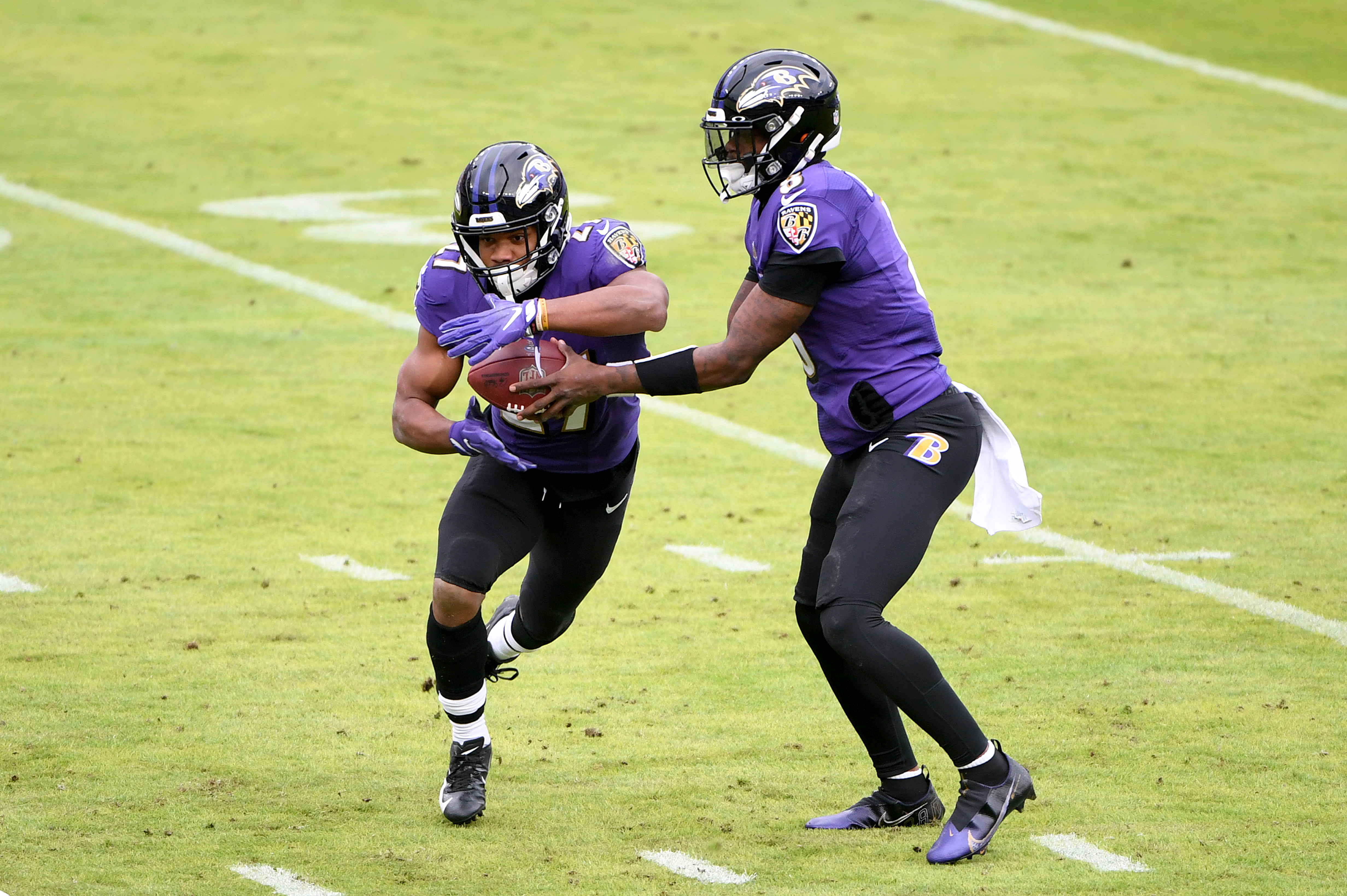 Ravens QB Lamar Jackson hands the ball off to JK Dobbins