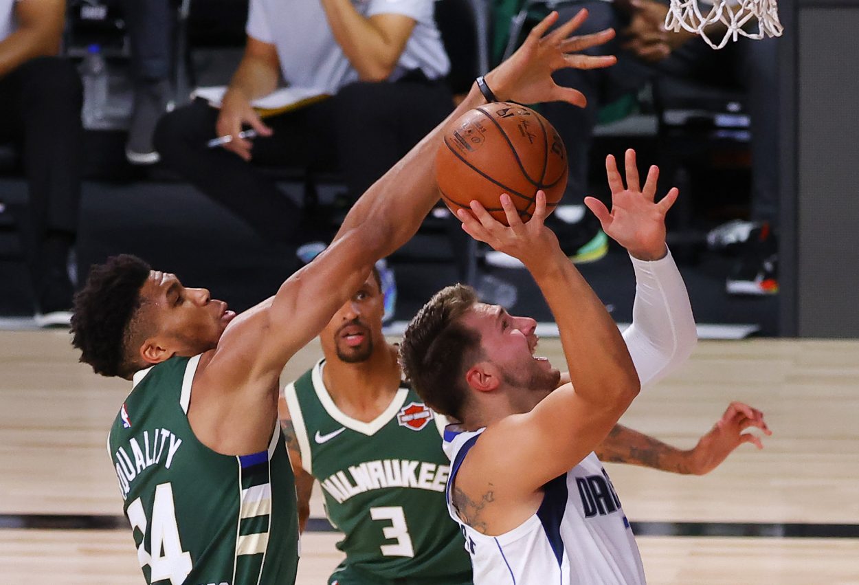 Milwaukee Bucks star Giannis Antetokounmpo (L) tries to block Dallas Mavericks guard Luka Doncic during an NBA game in August 2020