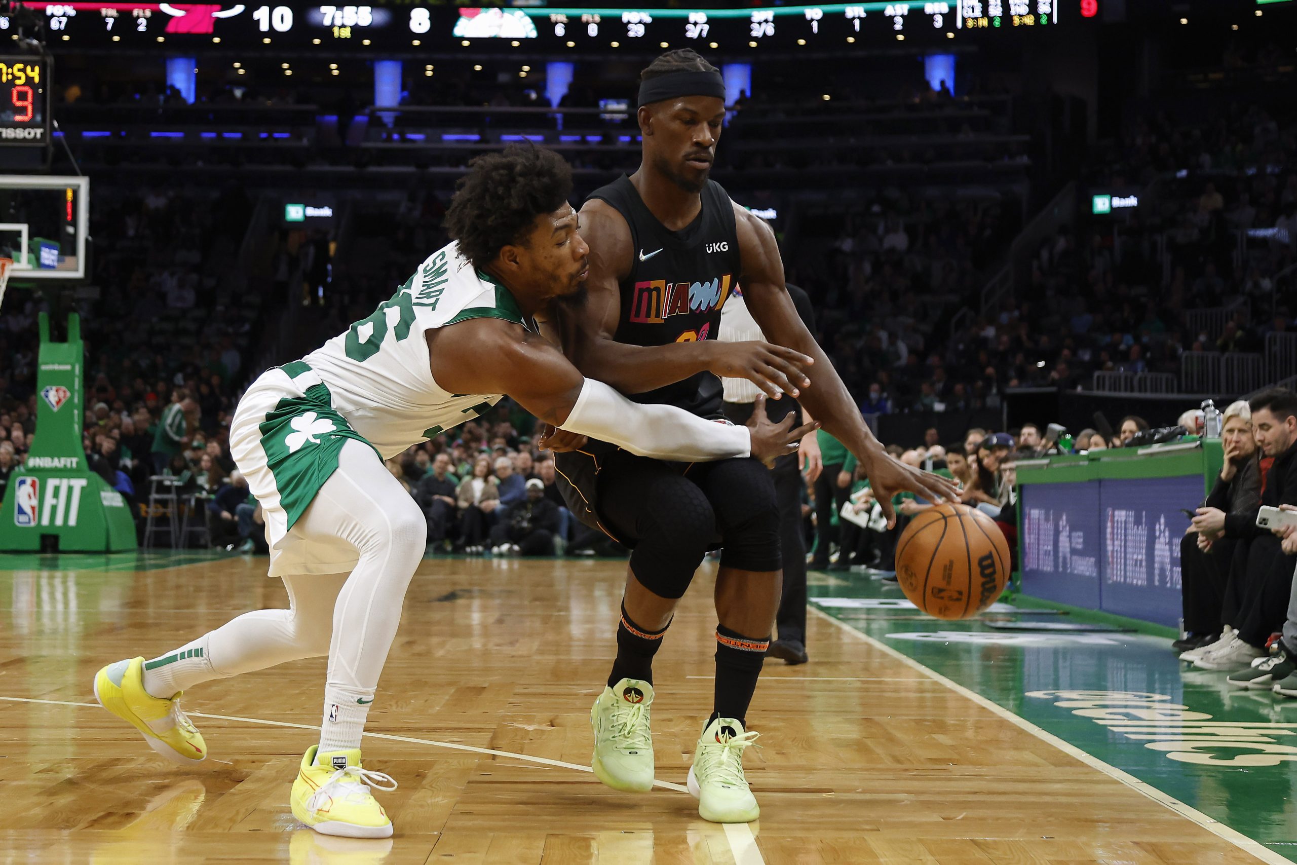 Marcus Smart of the Boston Celtics reaches in to try to steal the ball from Jimmy Butler of the Miami Heat.