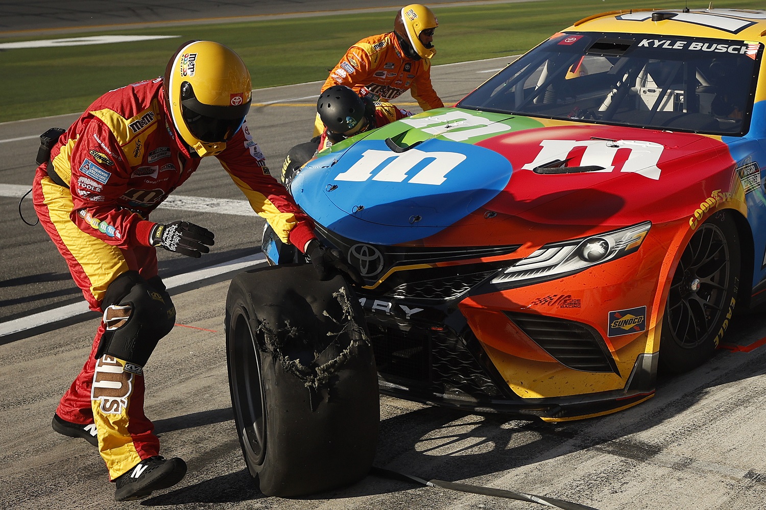 The pit crew removes a damaged tire on the No. 18 Toyota, driven by Kyle Busch, during the NASCAR Daytona 500.