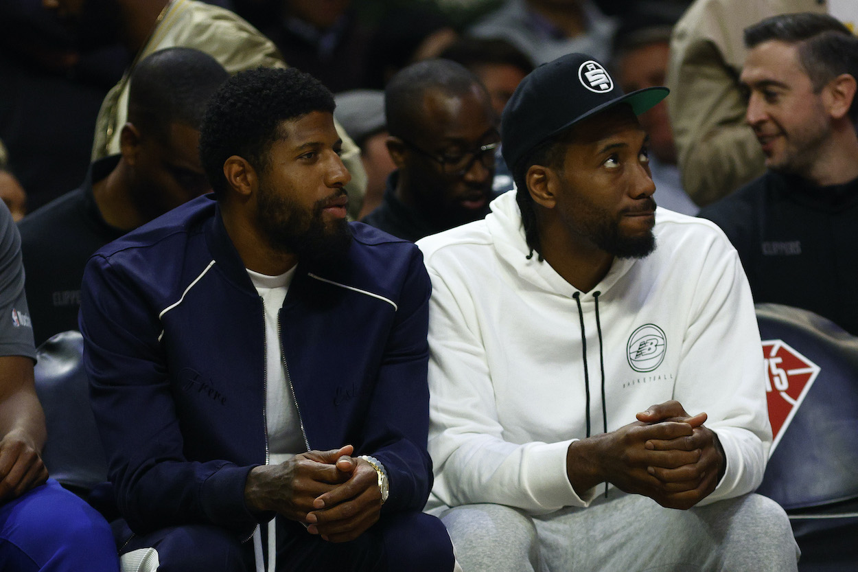 Paul George and Kawhi Leonard sit on the bench.