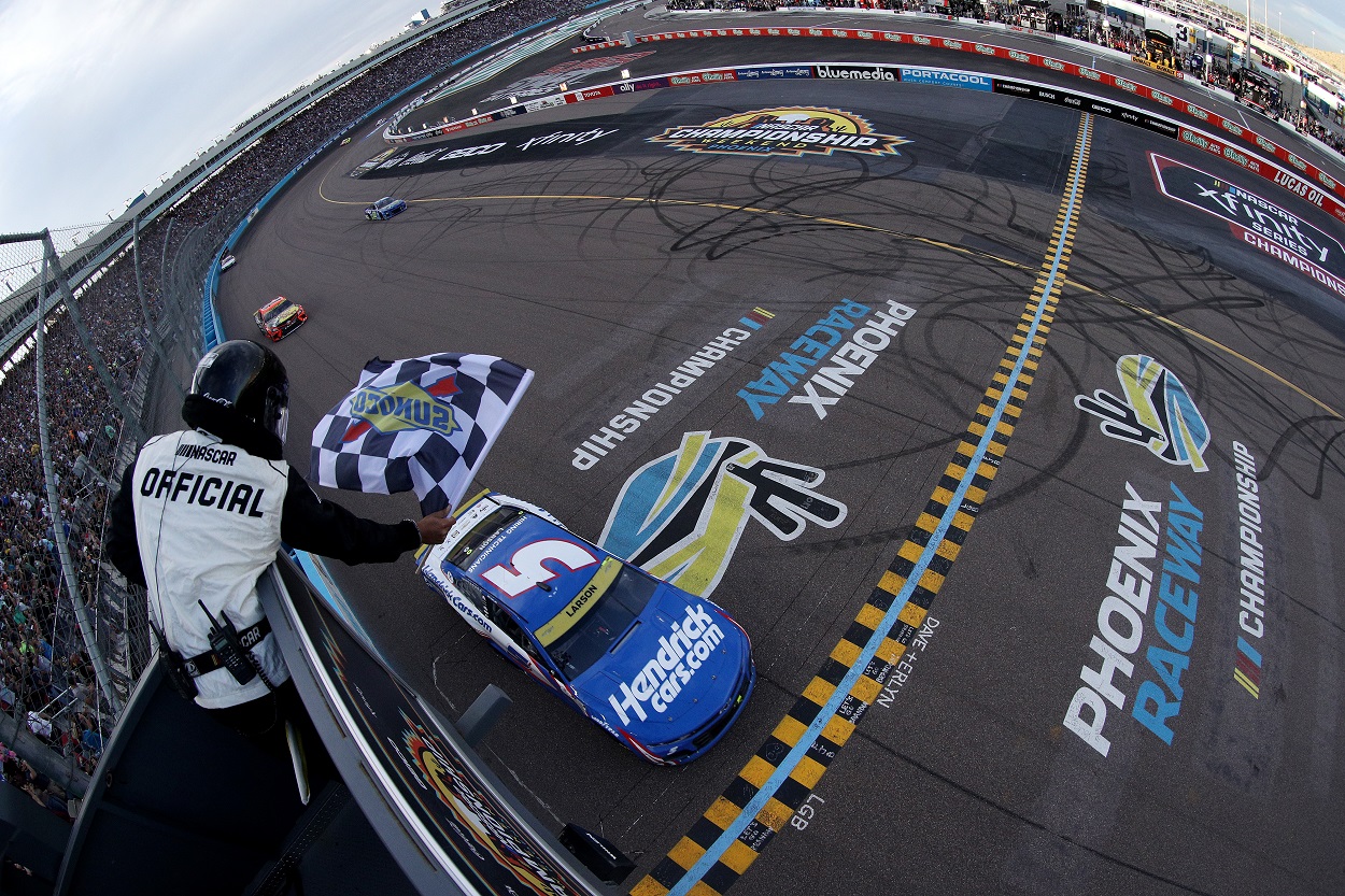 Kyle Larson crosses the Phoenix Raceway finish line to win the 2021 NASCAR Cup Series Championship