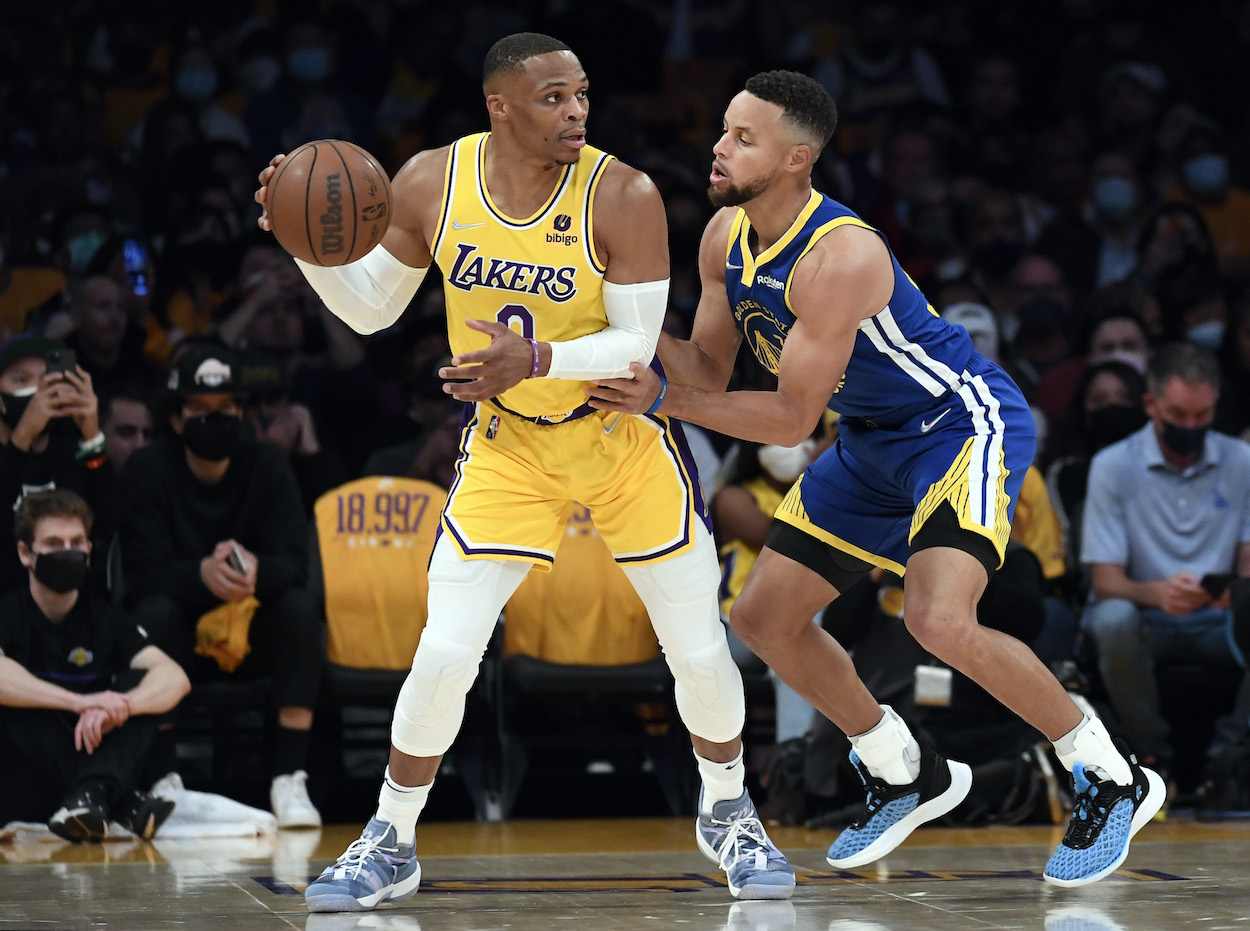 Russell Westbrook dribbles against Stephen Curry.