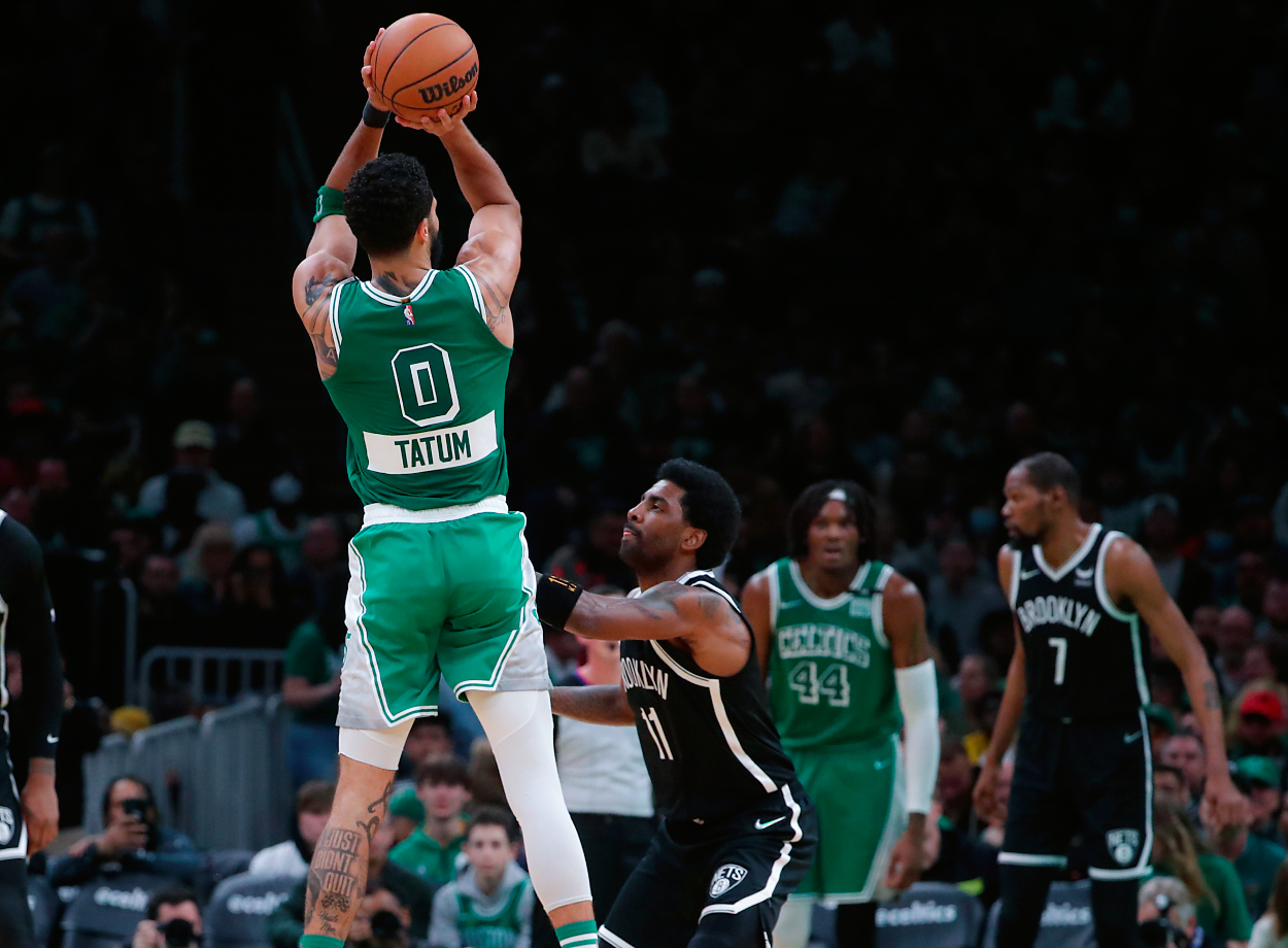 Boston Celtics forward Jayson Tatum makes a three-point basket over Brooklyn Nets guard Kyrie Irving during fourth-quarter NBA action.