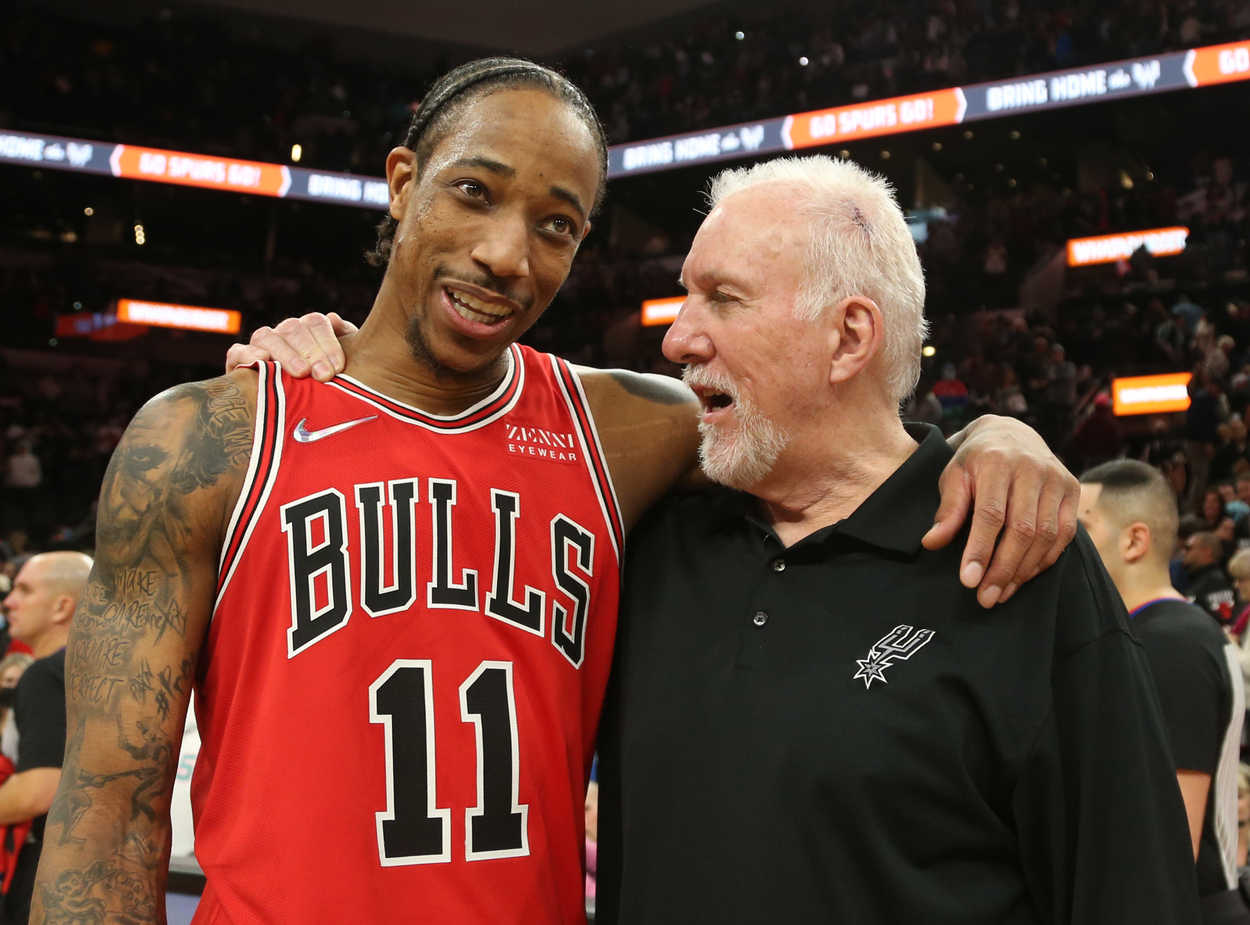 Chicago Bulls forward DeMar DeRozan and San Antonio Spurs head coach Gregg Popovich place their arms around one another.