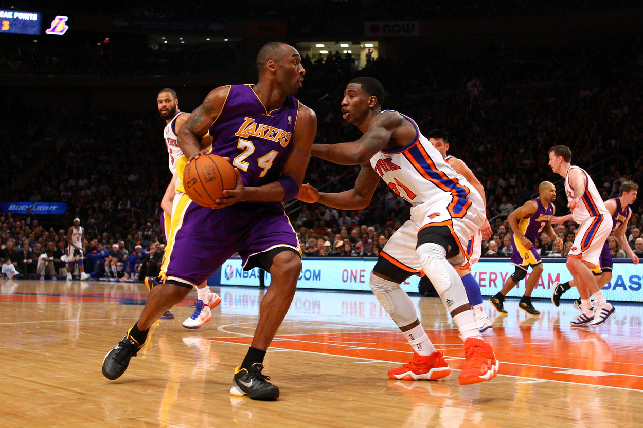 Los Angeles Lakers great Kobe Bryant looks to make a play while New York Knicks forward Iman Shumpert guards him.