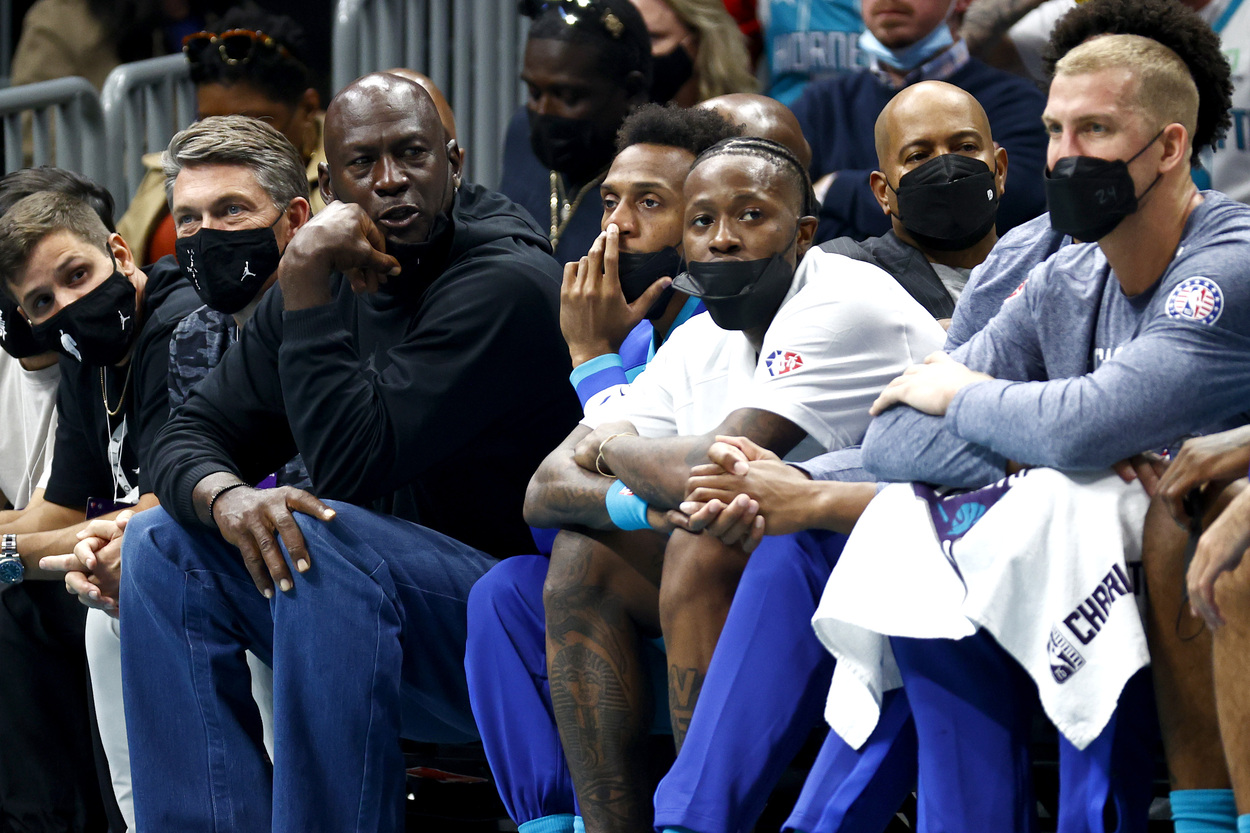 Charlotte Hornets owner Michael Jordan talks to his players on the bench.