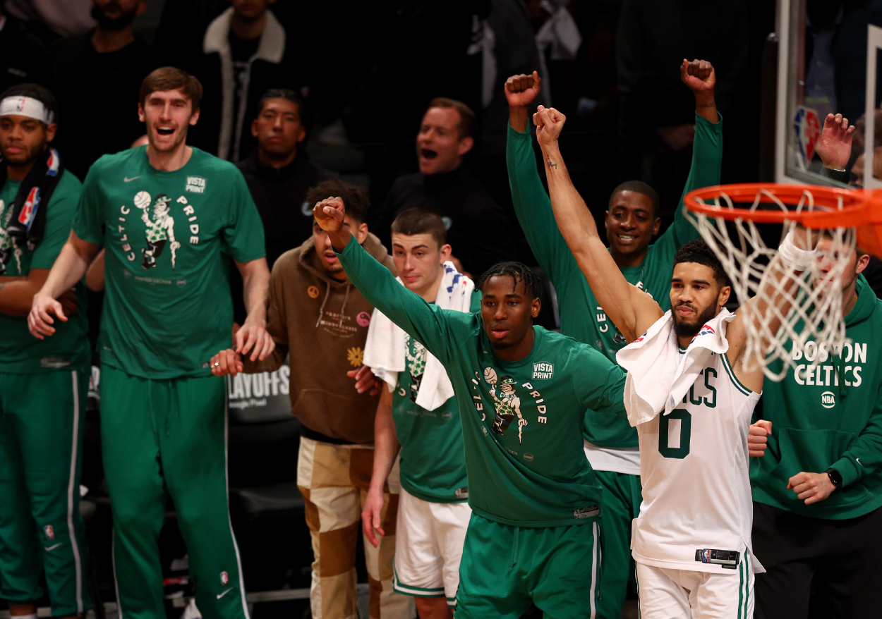 Jayson Tatum #0 of the Boston Celtics and the rest of his teammates on the bench celebrate.