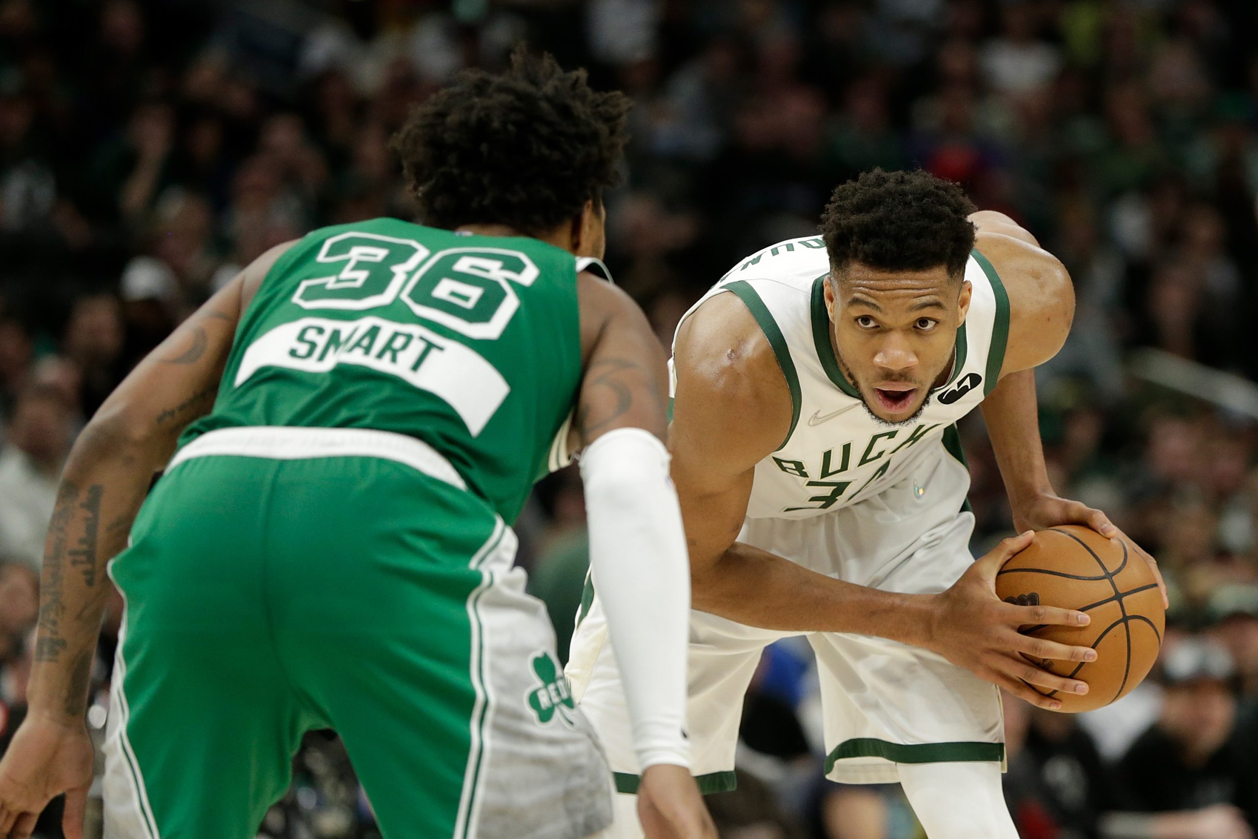 Giannis Antetokounmpo of the Milwaukee Bucks looks to drive while being guarded by Marcus Smart of the Boston Celtics.