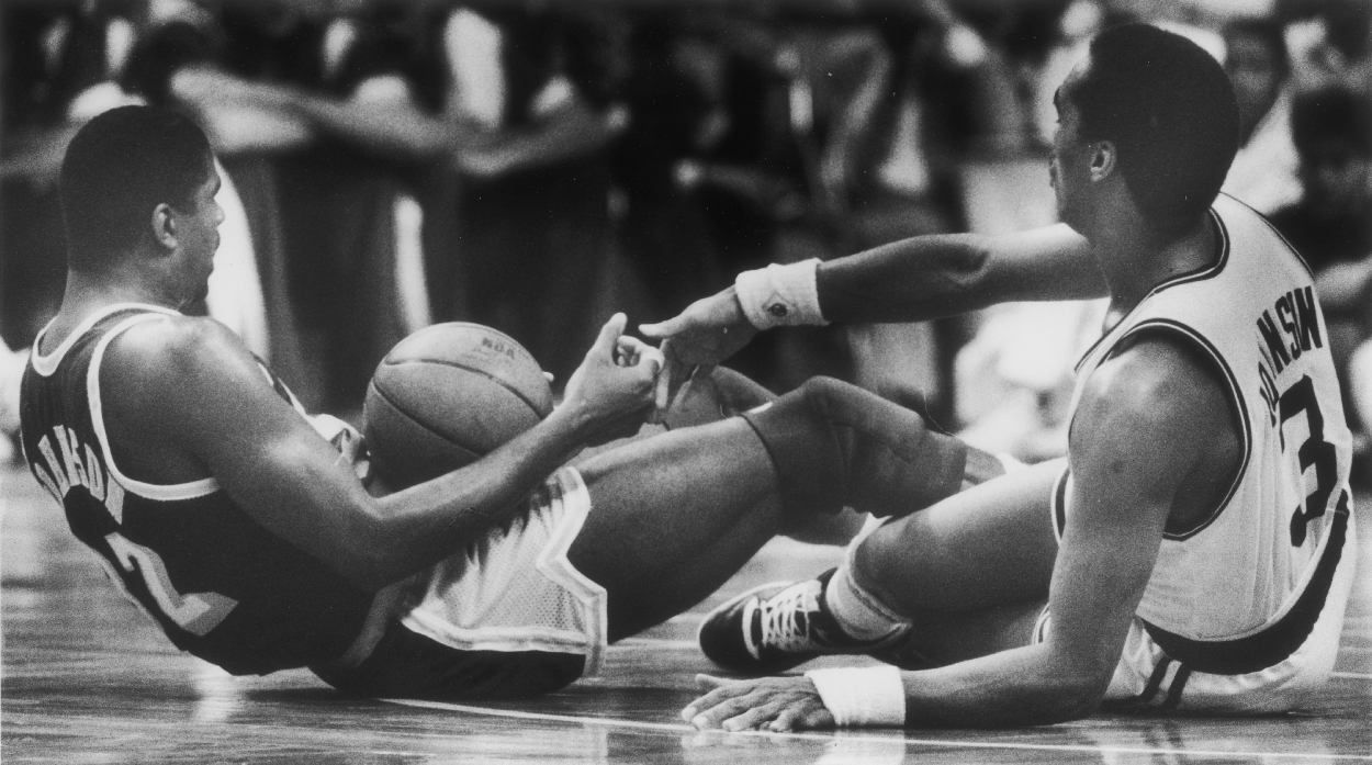The Celtics' Dennis Johnson helps the Lakers' Magic Johnson up after a first half tumble.