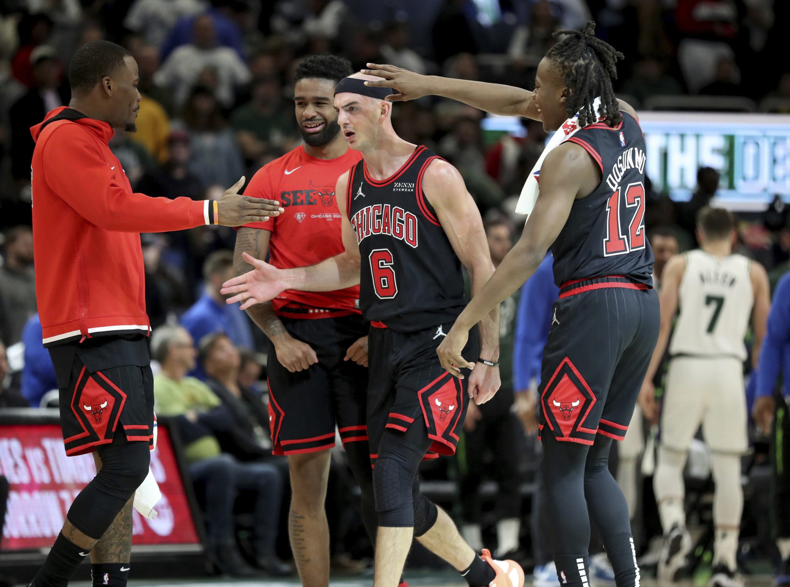Chicago Bulls guard Alex Caruso is congratulated by his teammates.