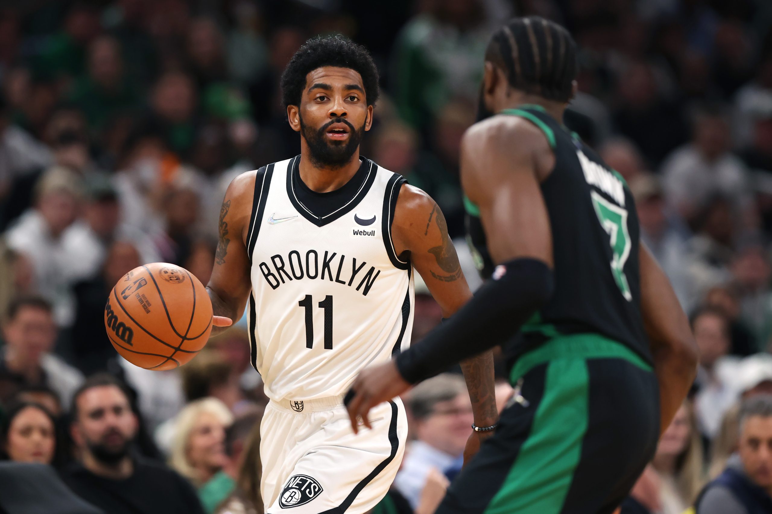 Kyrie Irving of the Brooklyn Nets dribbles against Jaylen Brown of the Boston Celtics.