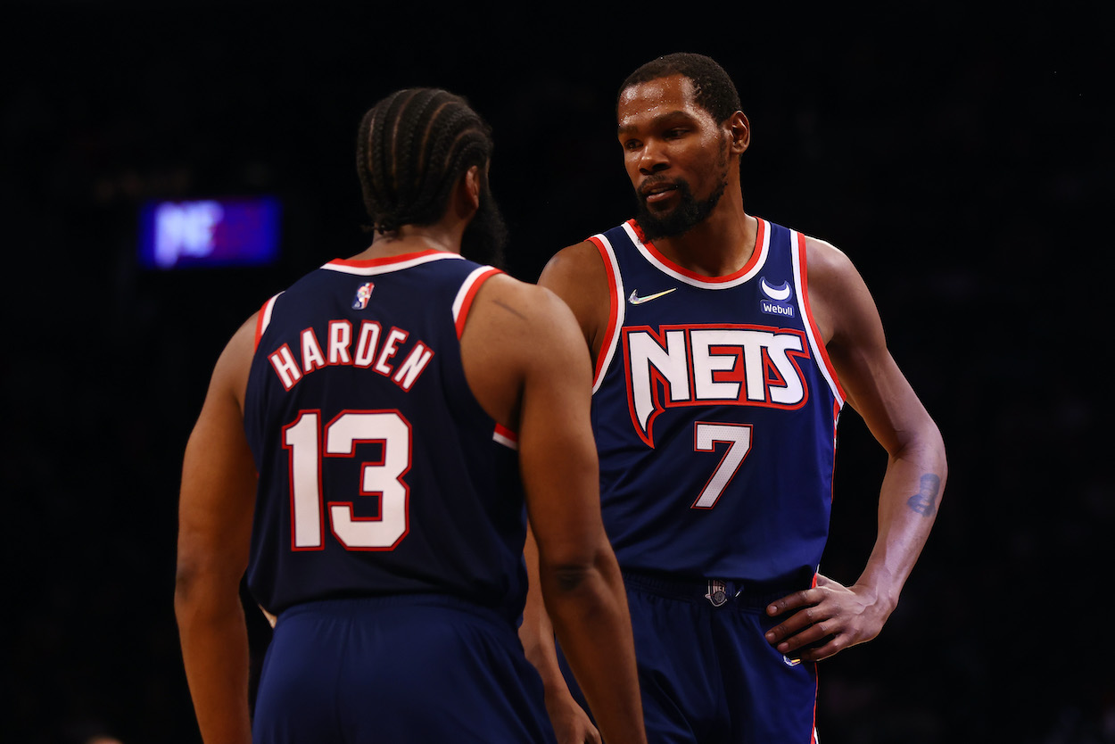 James Harden and Kevin Durant talk on the court.