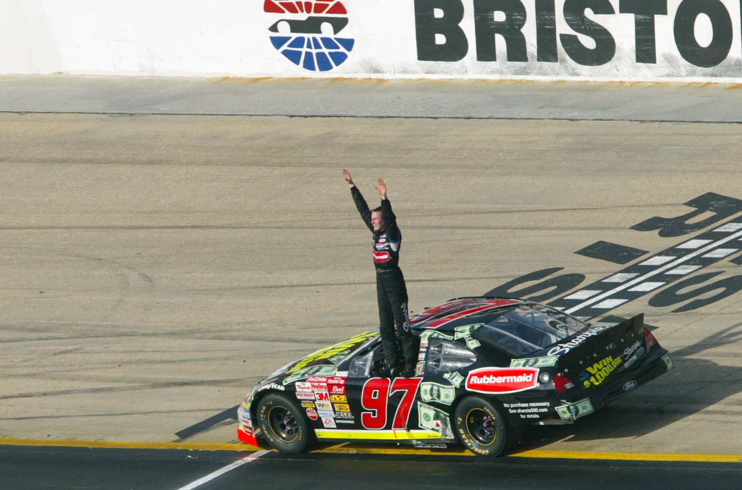 Kurt Busch celebrates his first Cup Series victory after the Food City 500 at Bristol Motor Speedway on March 24, 2002. | Adam Pretty/Getty Images