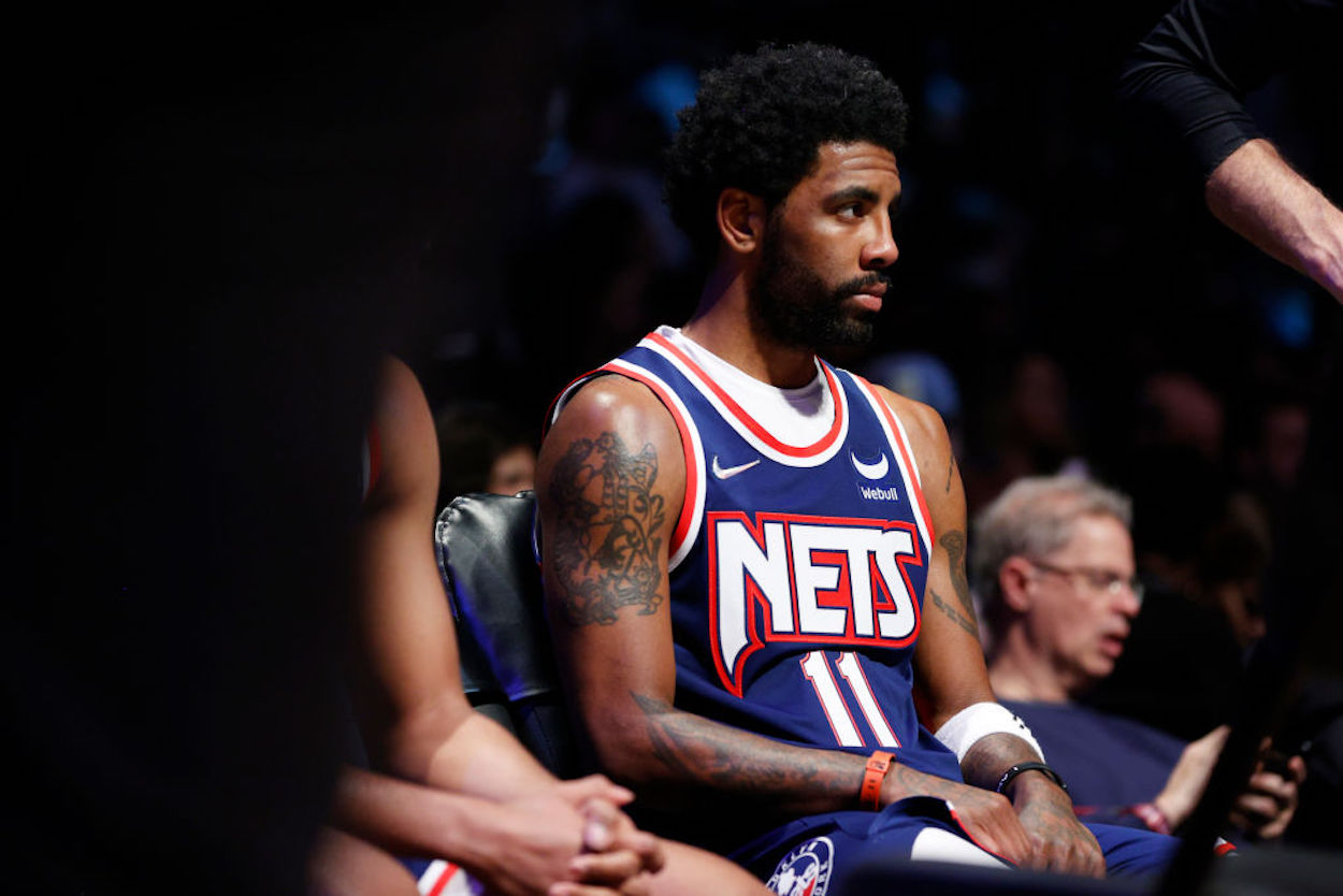 Kyrie Irving sits on the Brooklyn Nets bench