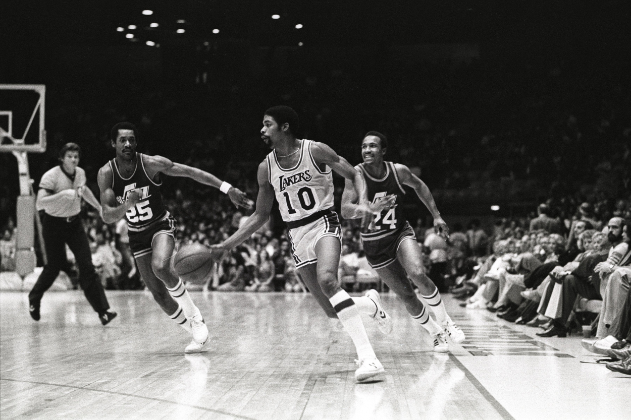 Guard Norm Nixon of the Los Angeles Lakers moves the ball against Ron Boone and Terry Furlow of the Utah Jazz.