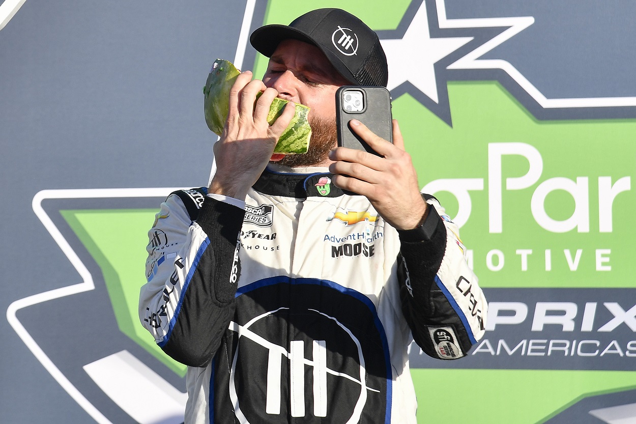 Ross Chastain celebrates with a watermelon after his win at the 2022 NASCAR Cup Series Echopark Automotive Grand Prix