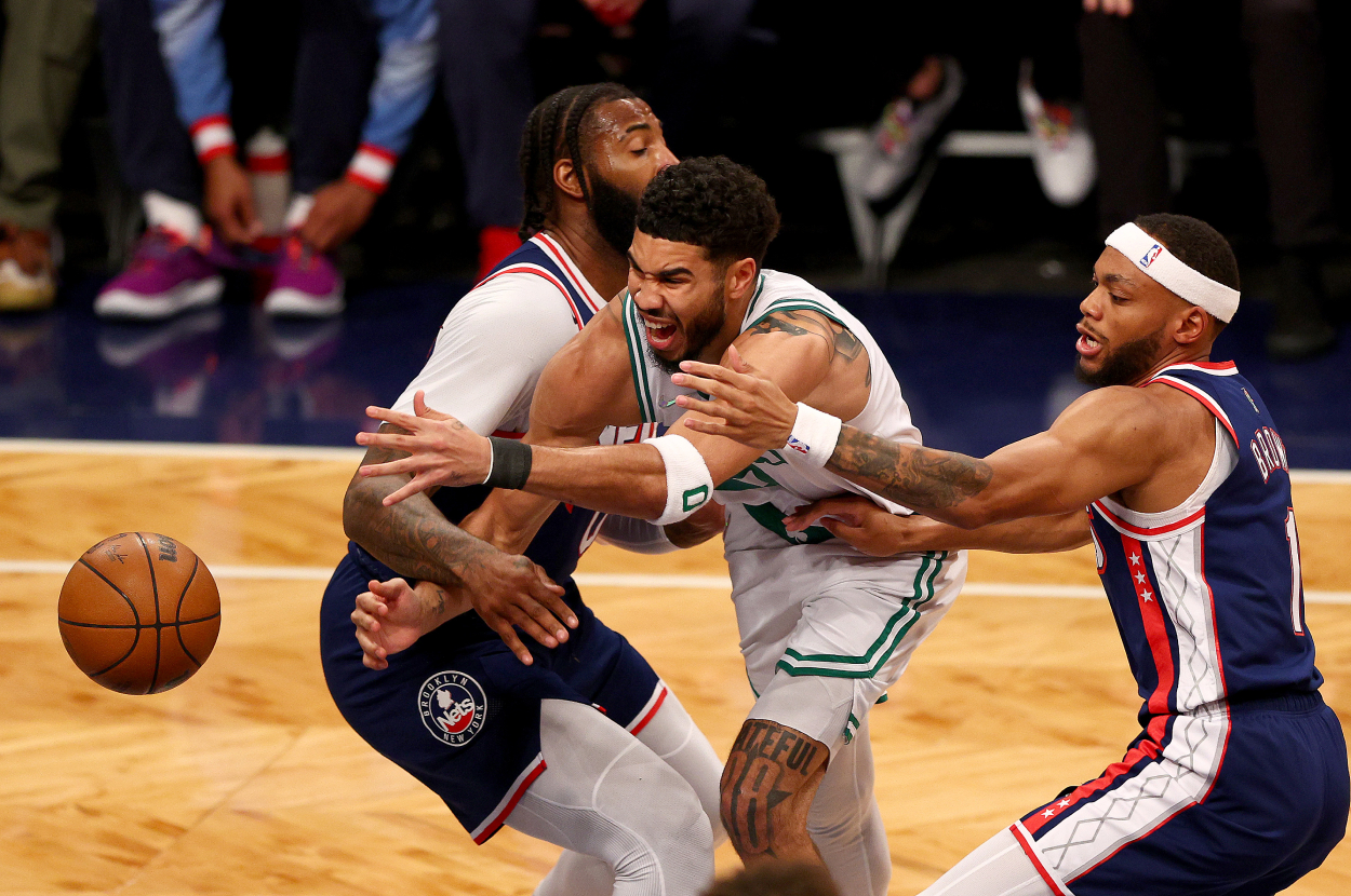 Andre Drummond #0 and Bruce Brown #1 of the Brooklyn Nets surround Jayson Tatum #0 of the Boston Celtics.