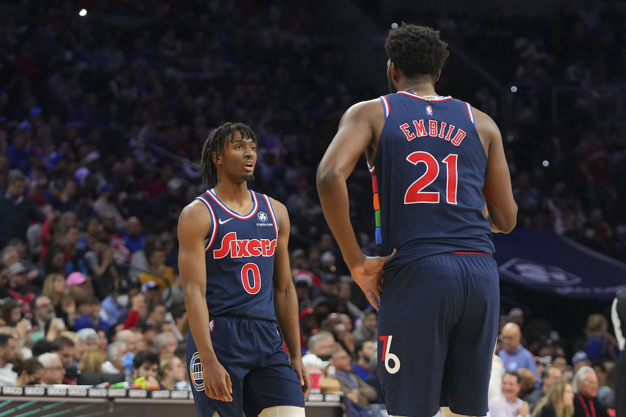 Tyrese Maxey and Joel Embiid talk on the court.