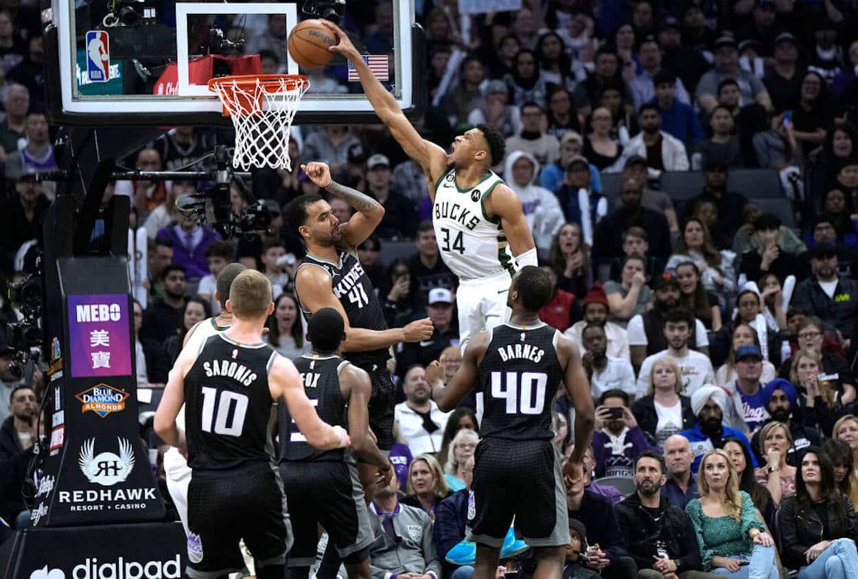 Giannis Antetokounmpo (C) dunks over the Sacramento Kings defense.