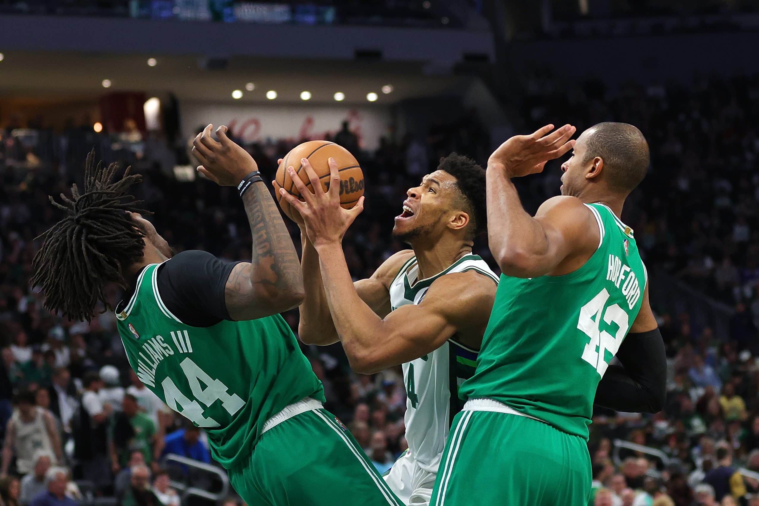 Giannis Antetokounmpo of the Milwaukee Bucks is fouled by Robert Williams III #44 of the Boston Celtics.