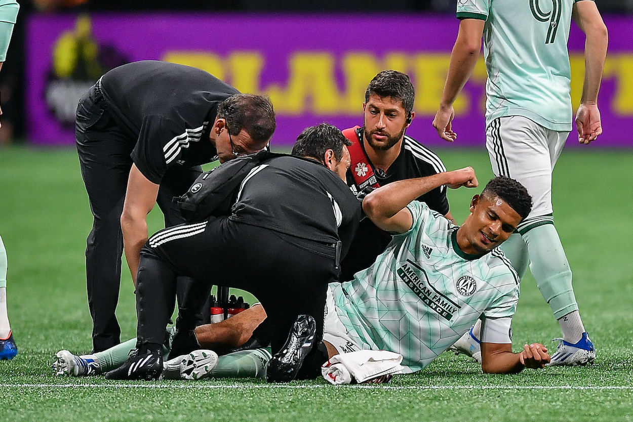 USMNT and Atlanta defender Miles Robinson reacts after injuring his leg during an MLS match .