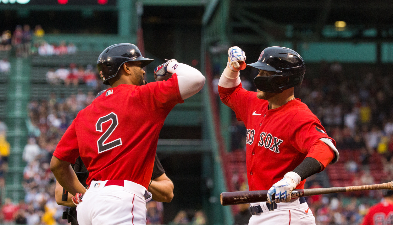 Xander Bogaerts #2 of the Boston Red Sox celebrates his 3-run home run with teammate Trevor Story.