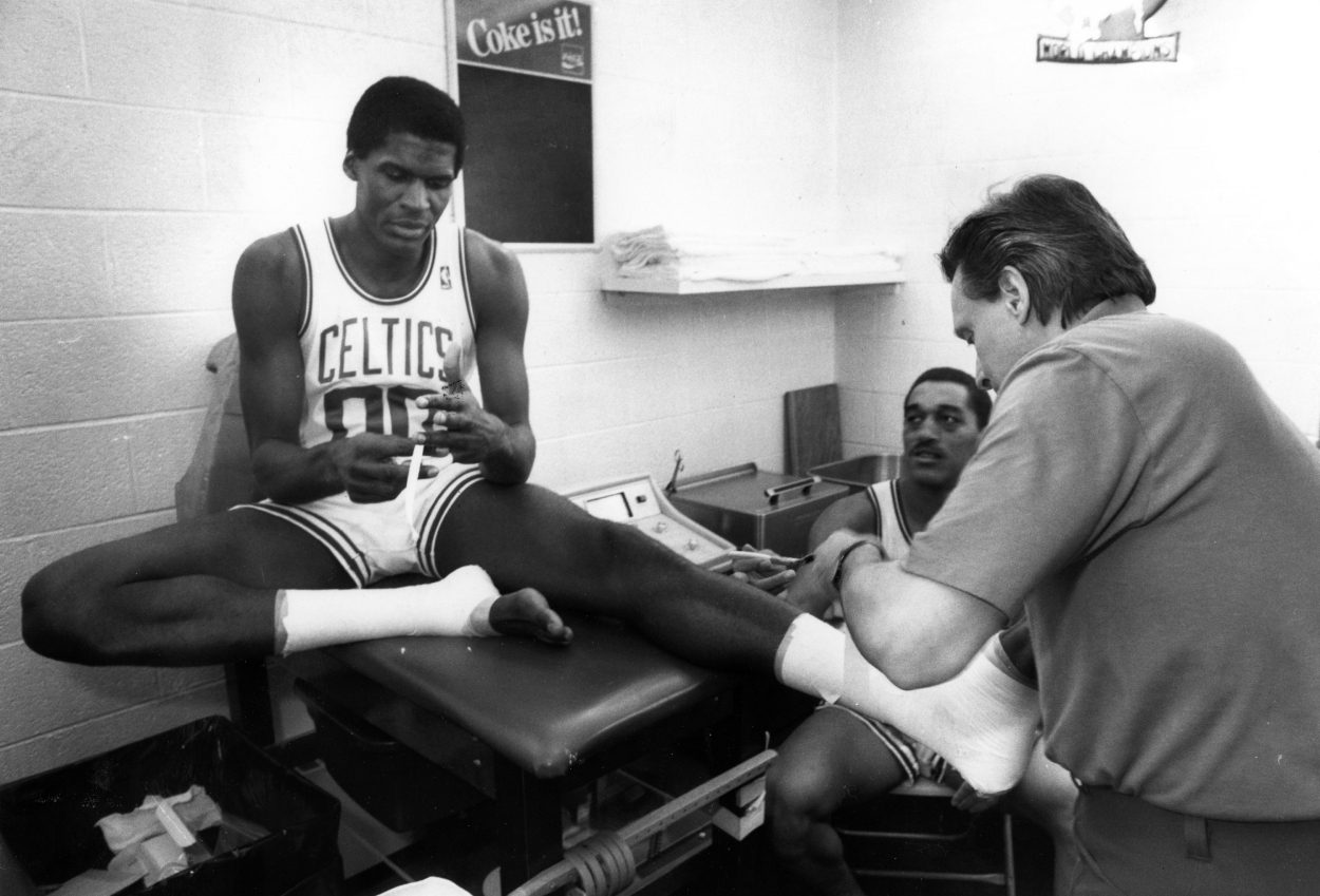 Boston Celtics trainer Ray Melchiorre, right, tapes Robert Parish's ankles at the Boston Garden, May 14, 1987.