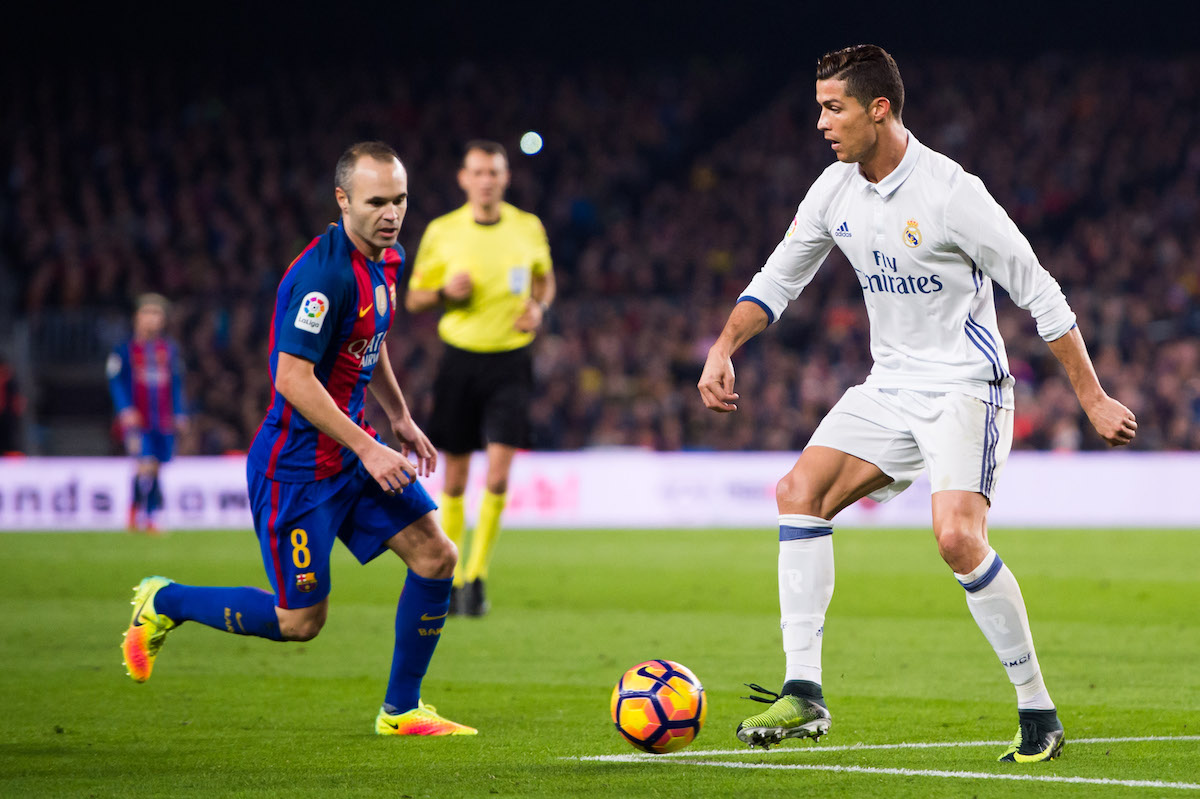 Cristiano Ronaldo controls the ball next to Andres Iniesta
