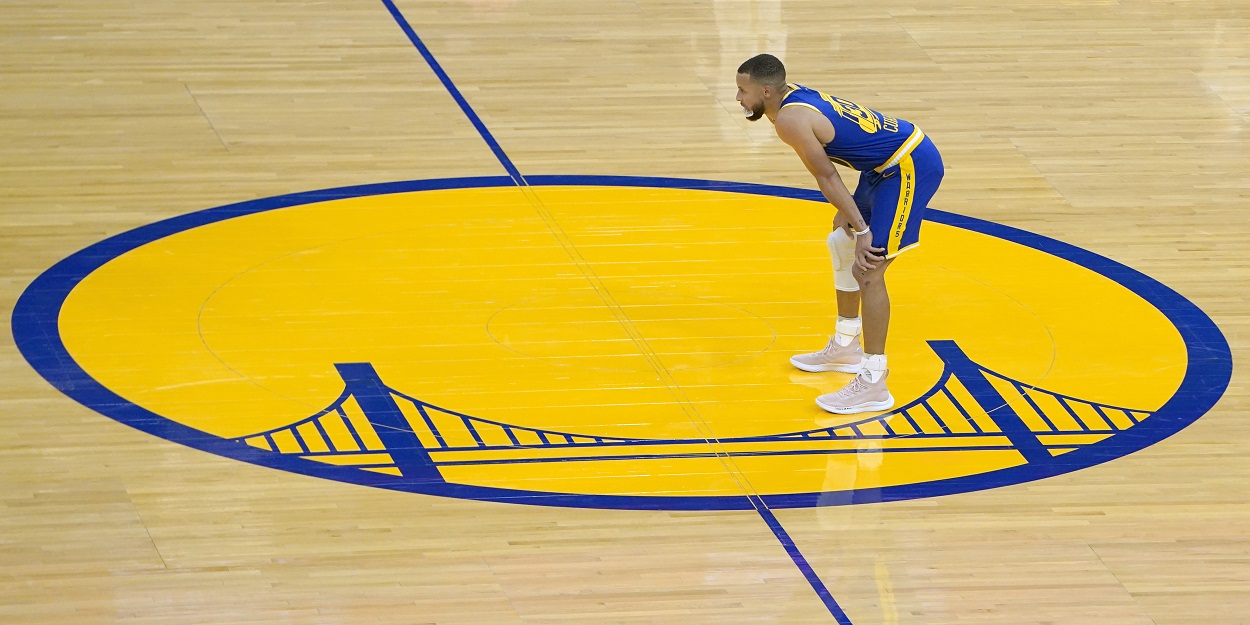 Stephen Curry stands on the Golden State Warriors logo in April 2021