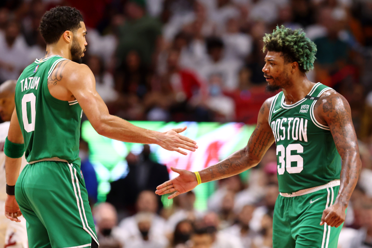 Jayson Tatum, left, and Marcus Smart of the Boston Celtics high five during the second quarter against the Miami Heat.